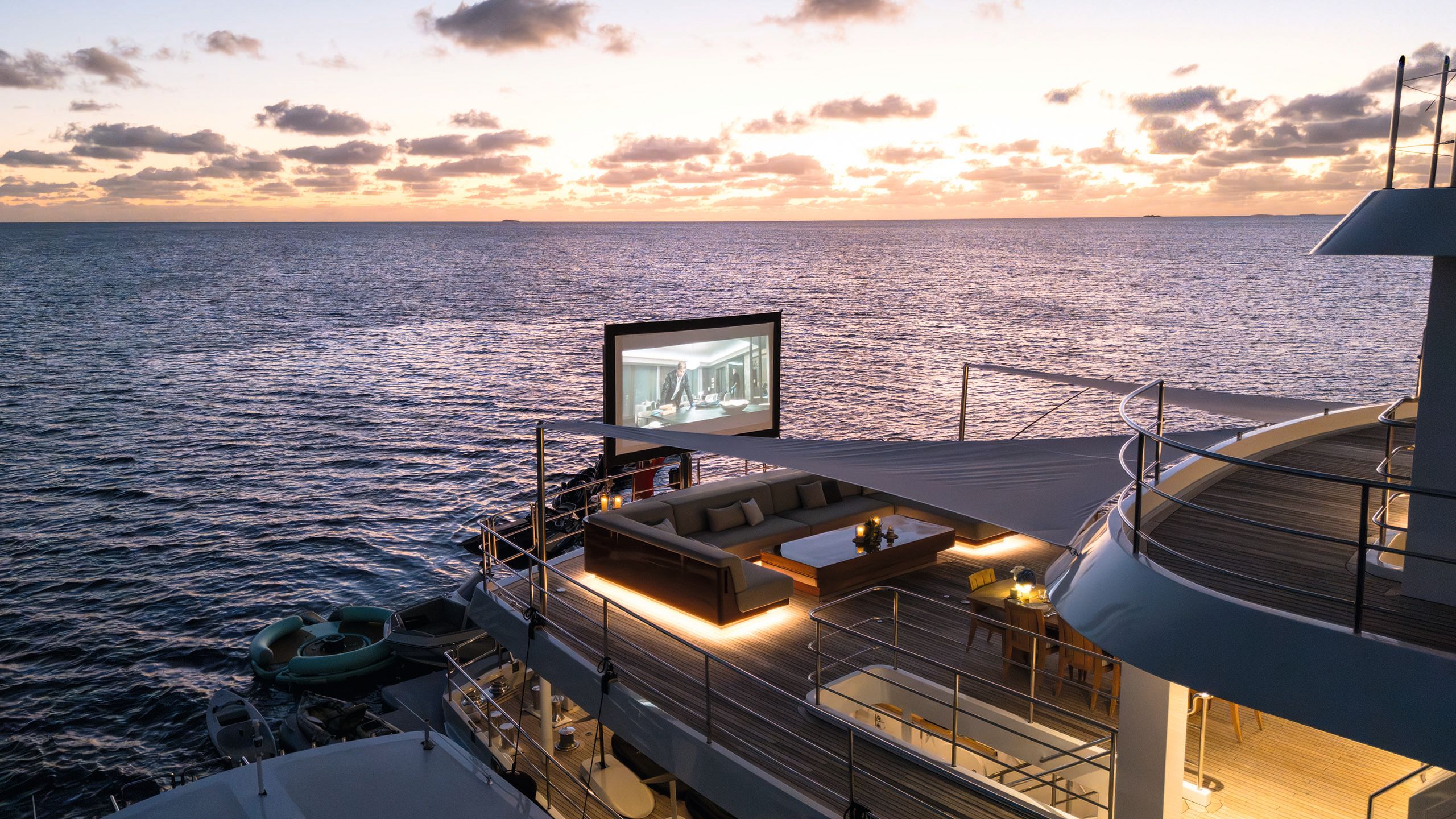 A large cinema screen set up on an outdoor deck at dusk