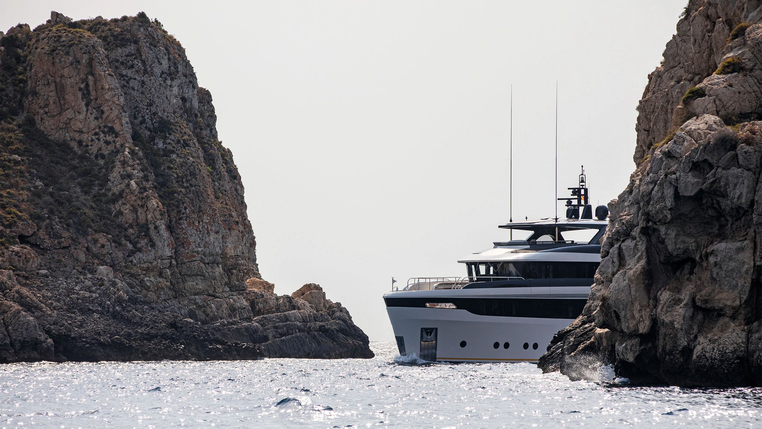 Lalabe peaking around the corner of a cliff on the water