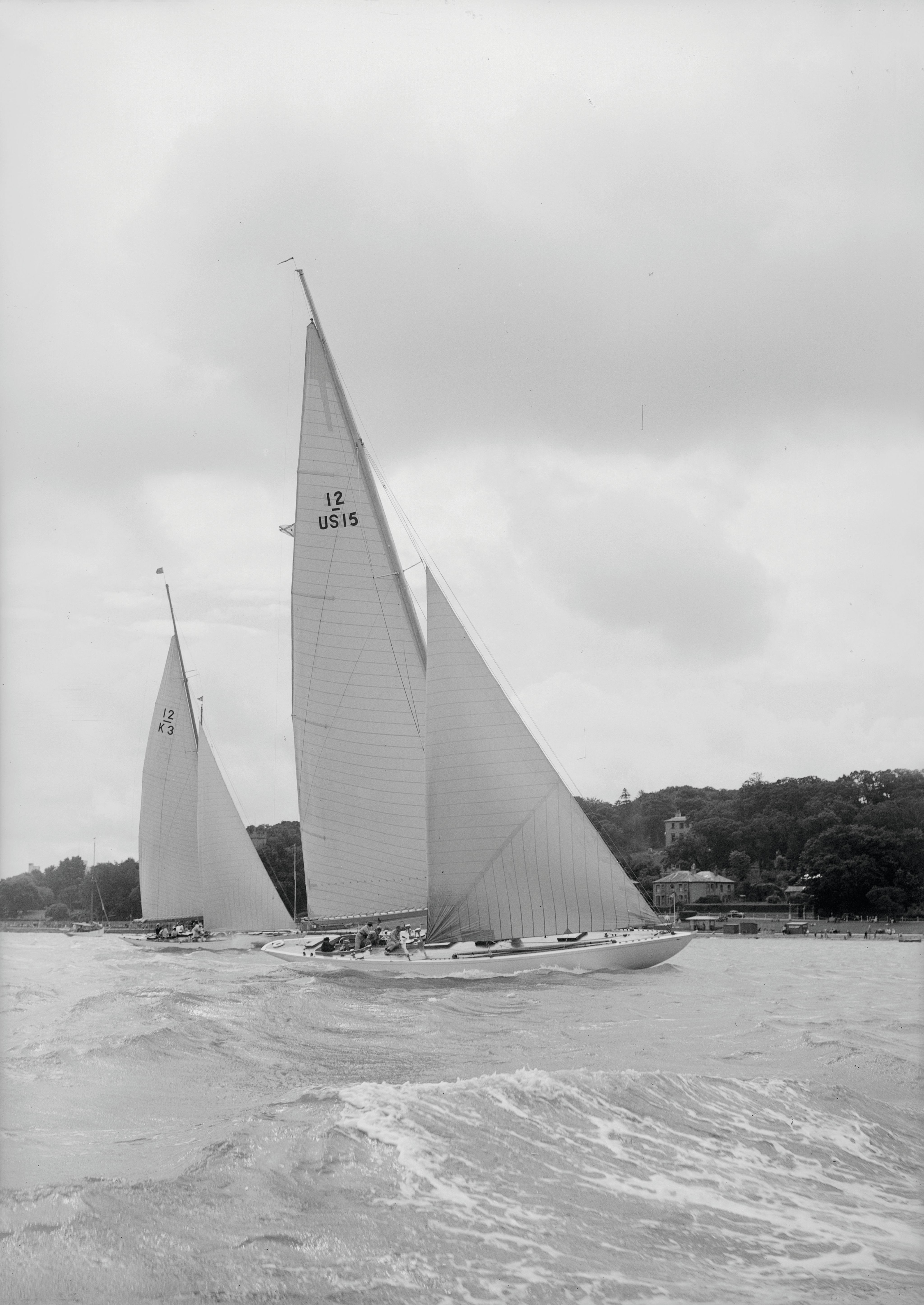 Black and white photo of two sail boats with huge sails on the water