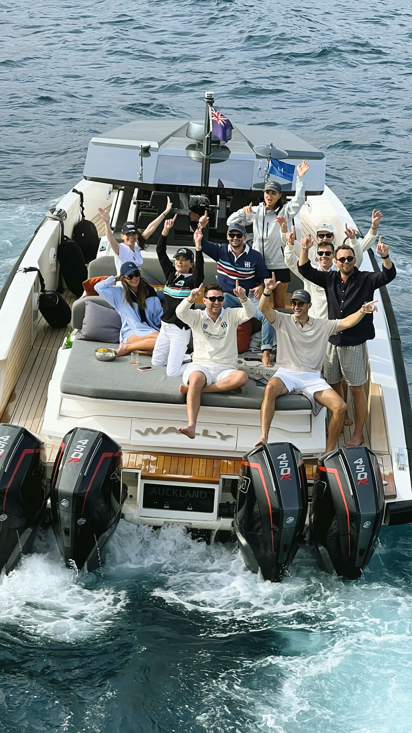 Ten people crowded on to a tender. They're mostly all wearing shorts, tops and sunglasses with baseball caps