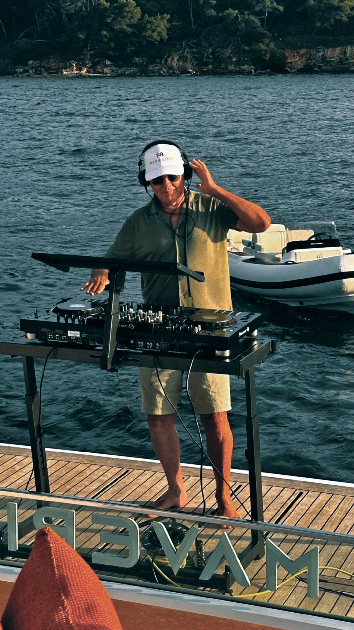 Owen on the decks. He's wearing headphones, a cap, shirt and shorts