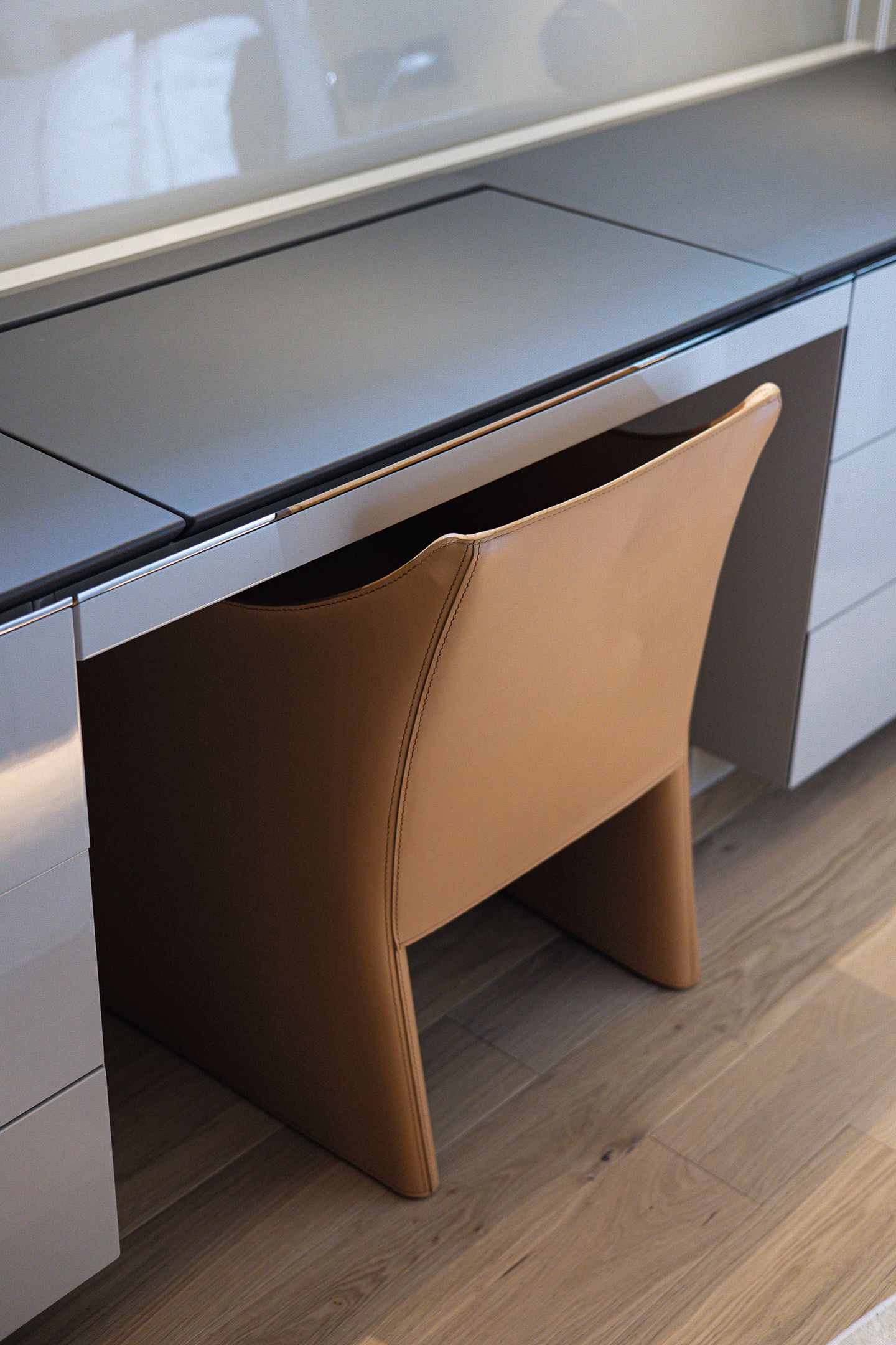 Close-up of brown leather chair at a counter/desk area