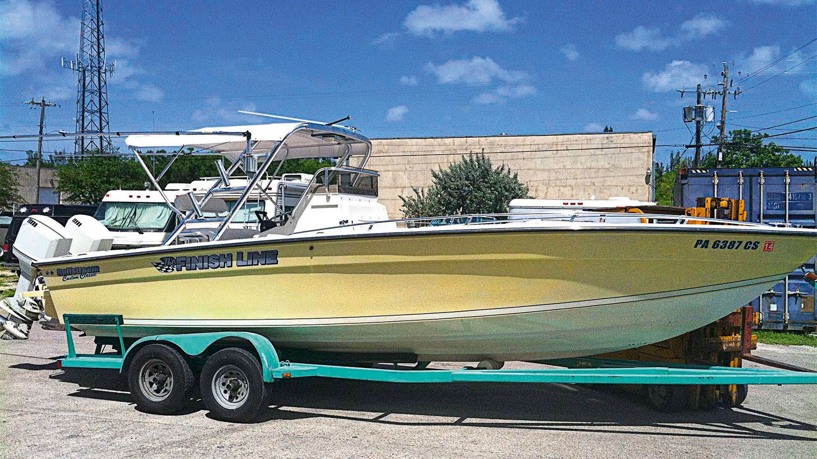 A small yellow and white boat called Finish Line