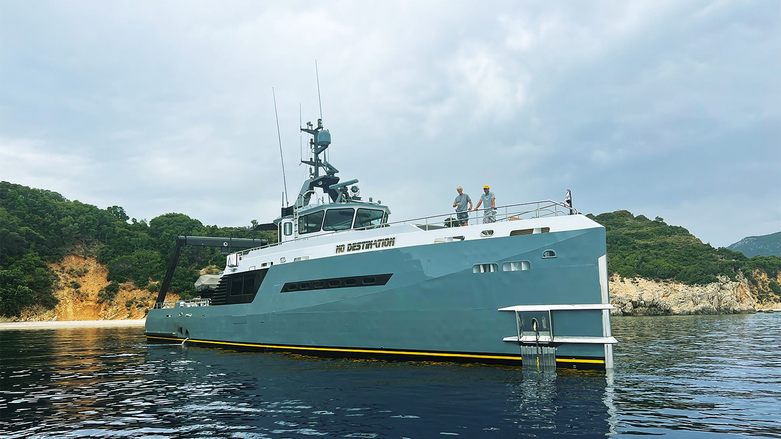 No Destination on the water. It has a turquoise hull with a yellow stripe along the bottom