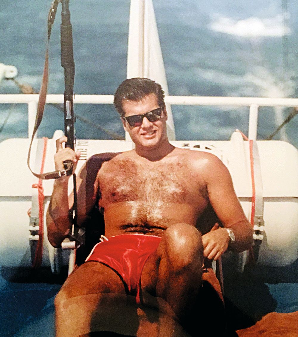A photo of young Pateras - he is topless and wearing red shorts and sunglasses