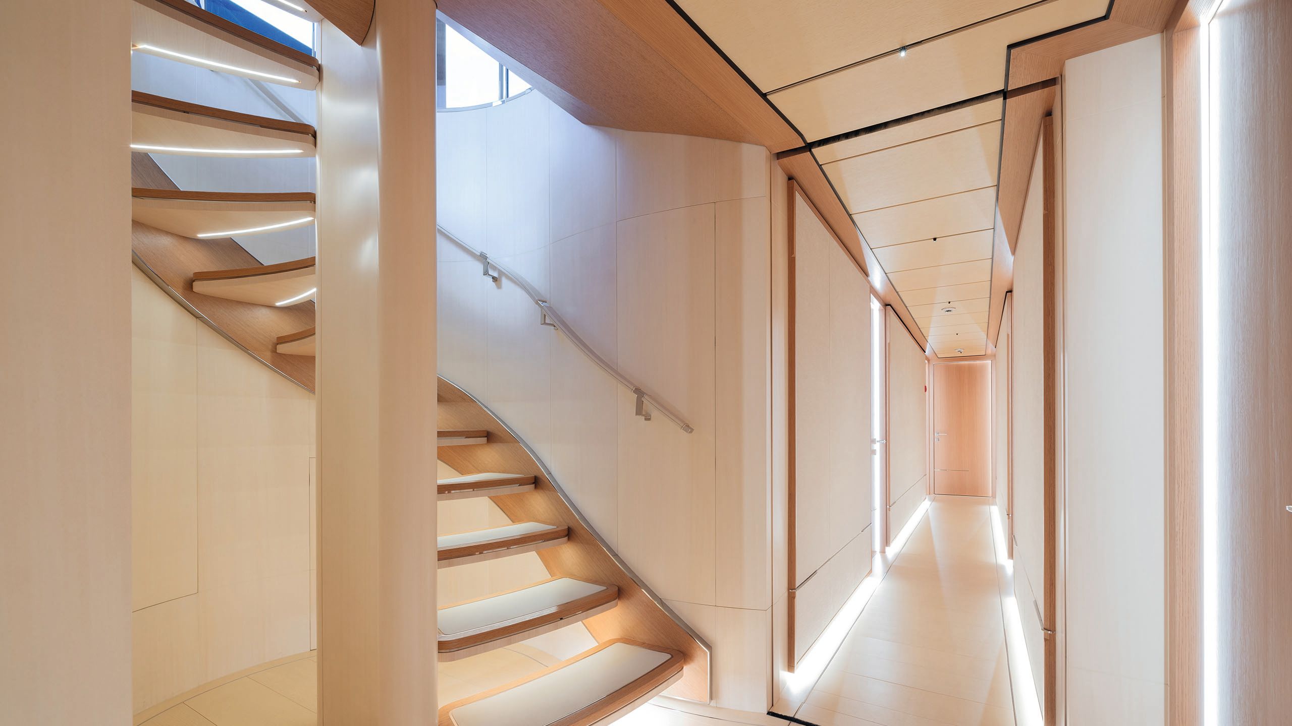 View from the bottom of the staircase, looking at it from the side and down a corridor