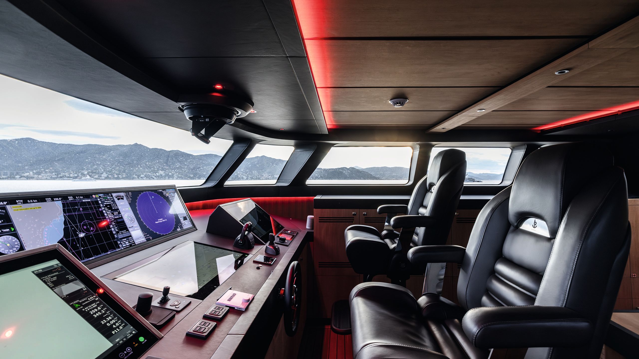 Two black leather seats in front of a large panel of instruments with dials and screens