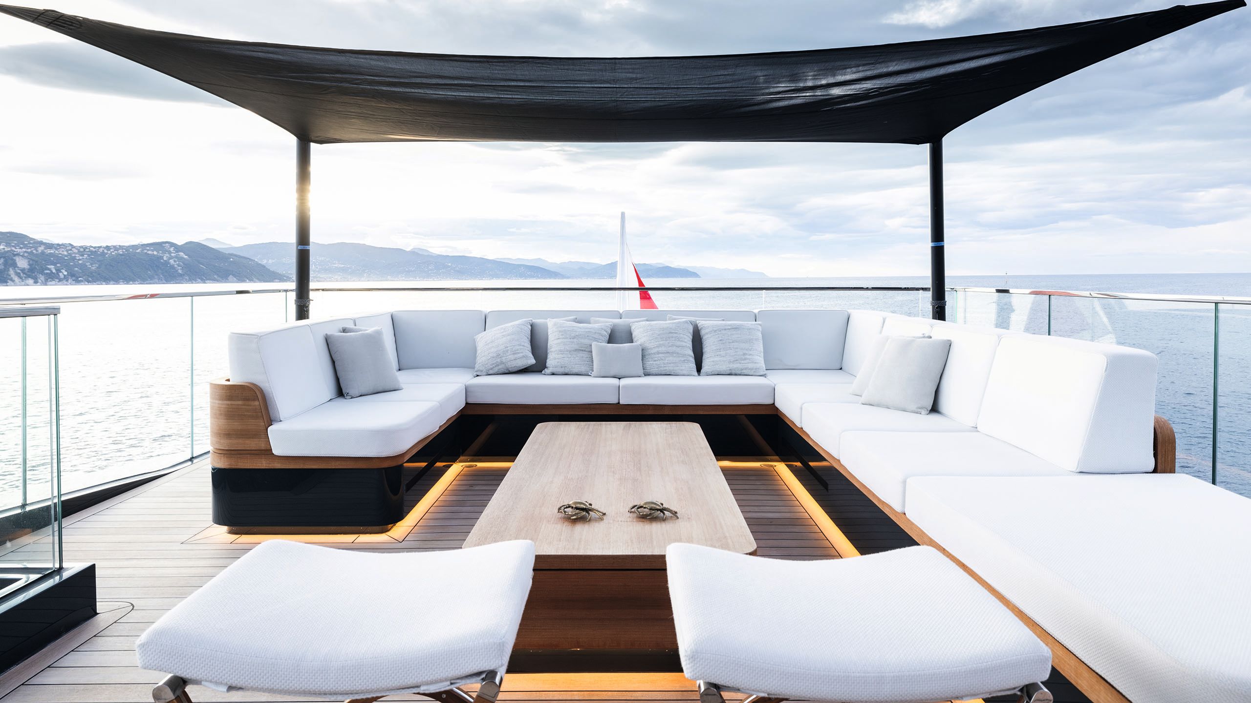 Large u-shaped, underlit sofa with white cushions and a rectangular coffee table in the centre