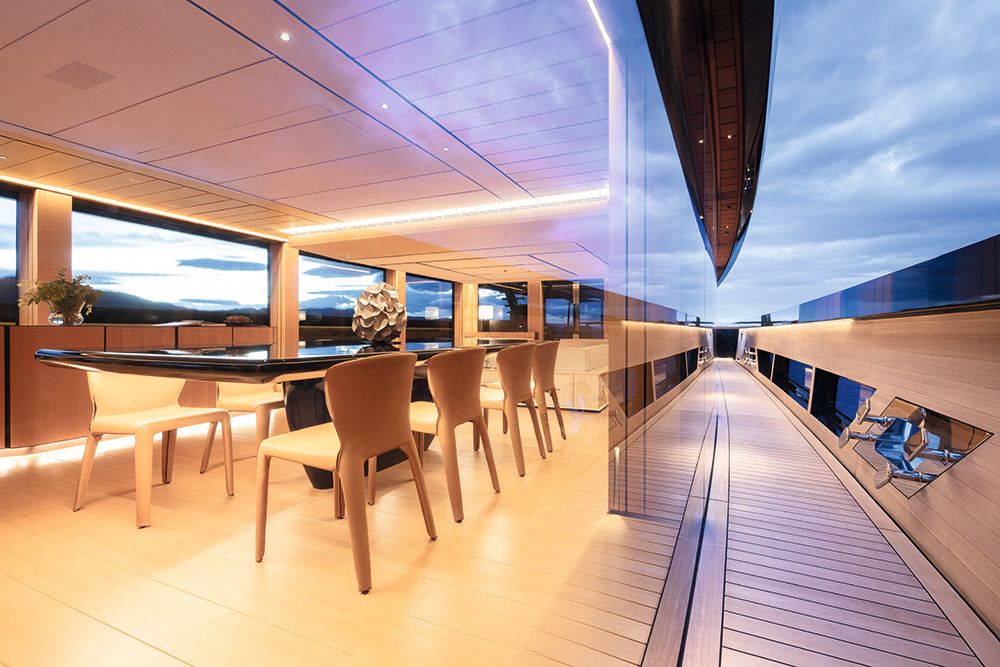 View from outside on the deck, looking into the dining area, where the table has a glossy black top