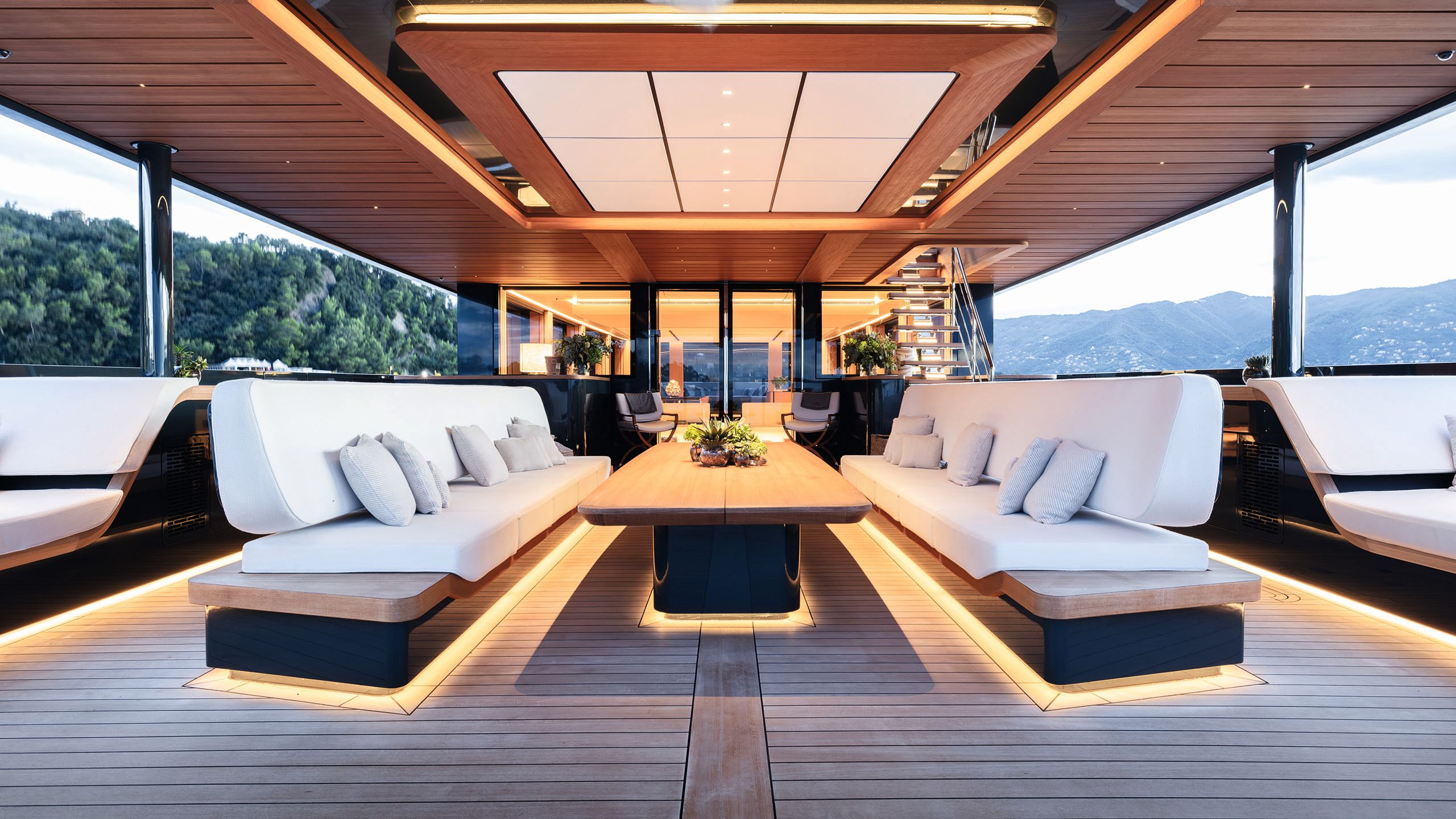 Two long sofas facing each other. They are underlit and have white cushion pads. A rectangular coffee table is the middle between them