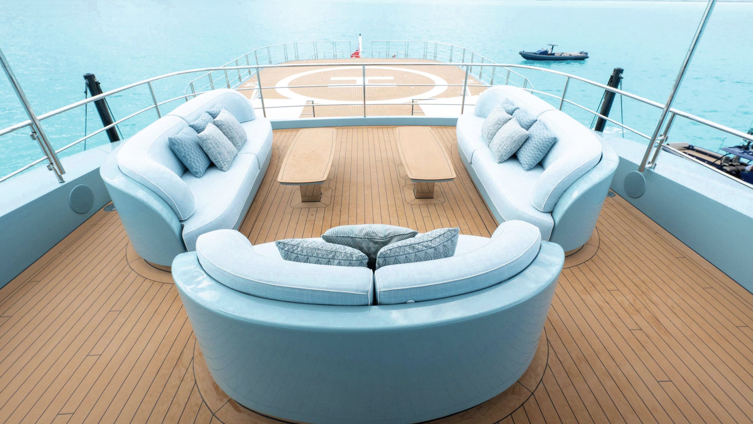 Three curved turquoise seats arranged in a u-shape above the helipad deck