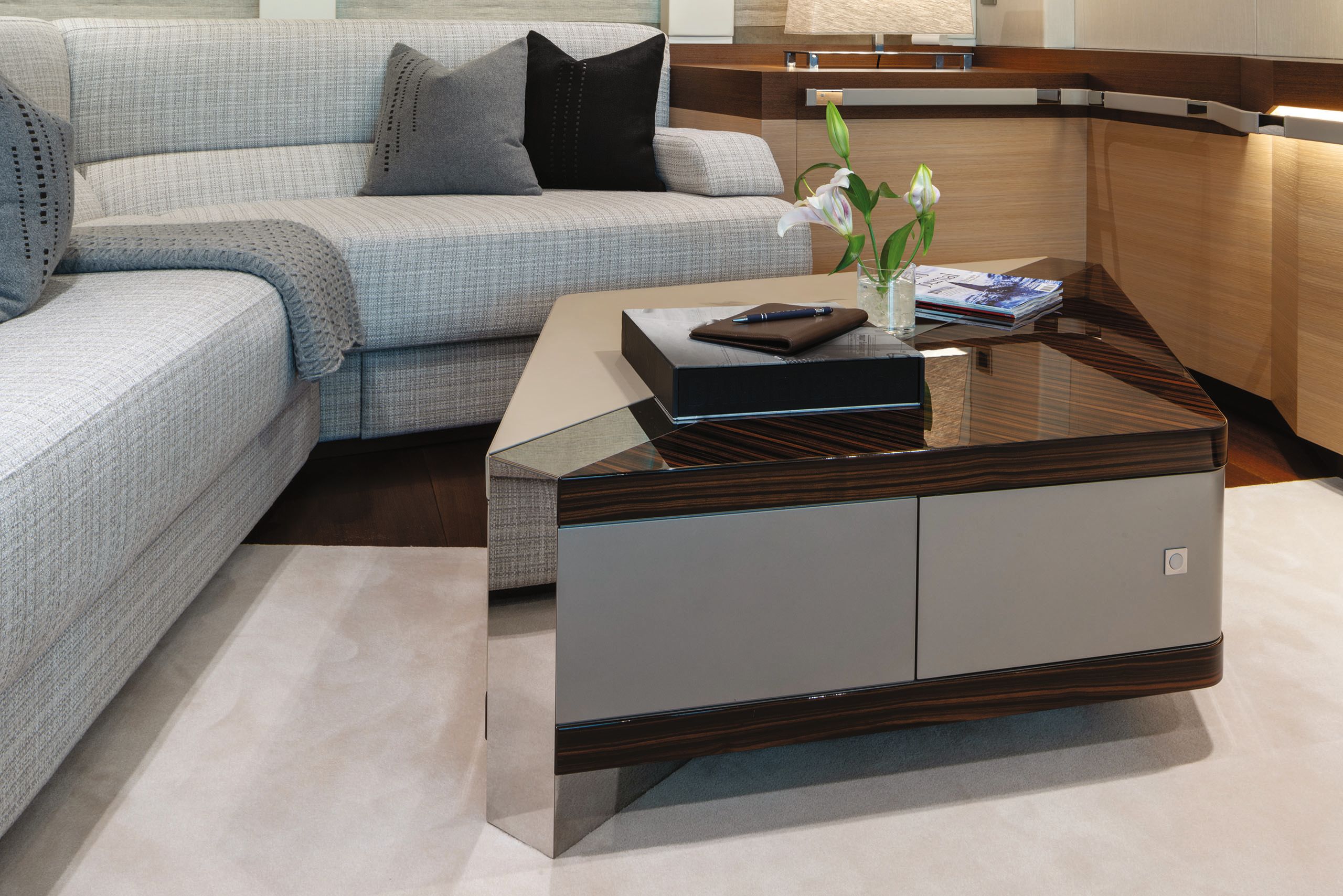 Close-up of rhomboid shaped coffee table in the cinema - it's a mix of neutral and mirrored materials and wood
