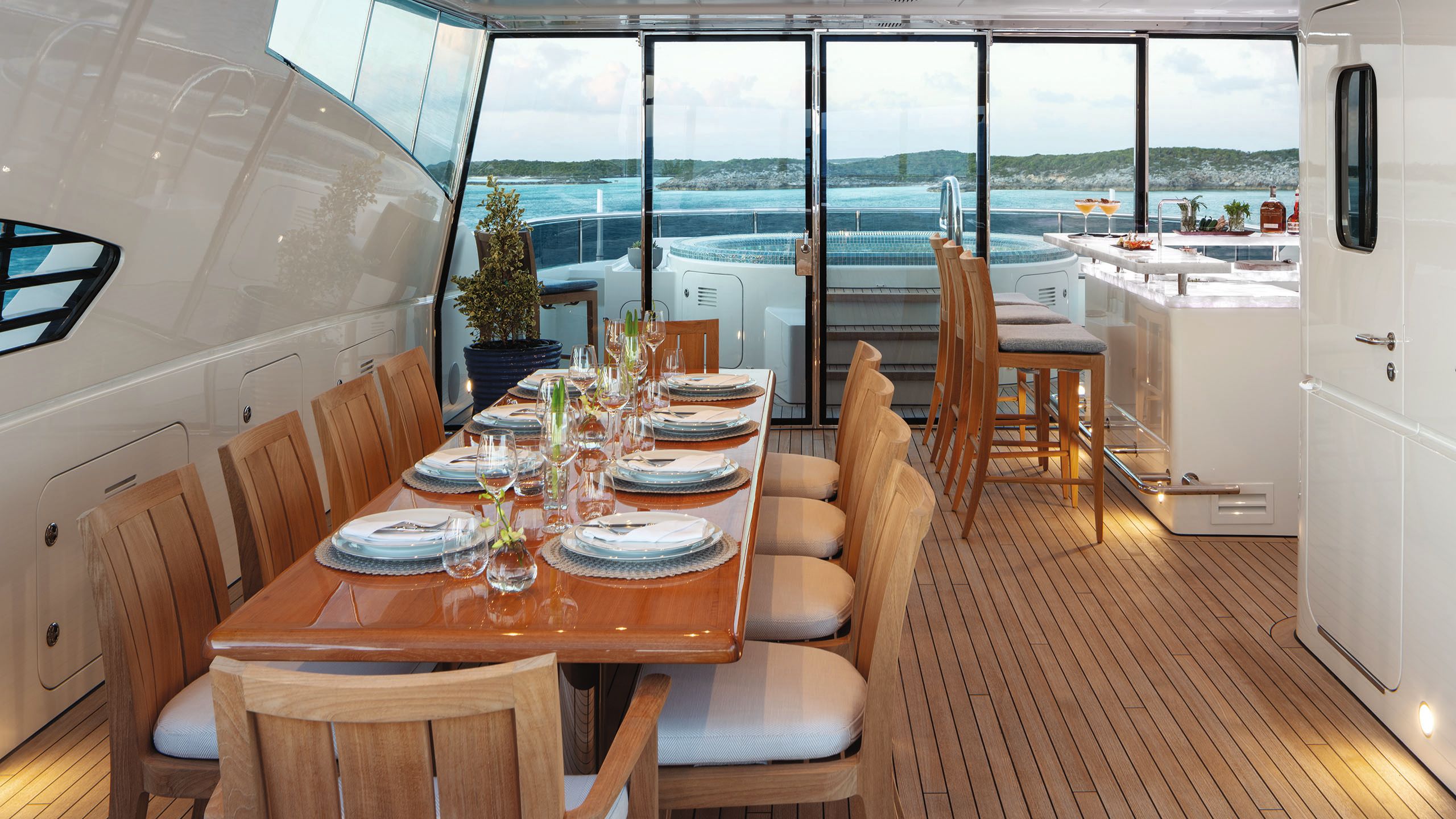 Long dining table with seating for 10; the spa pool is in the background on the deck