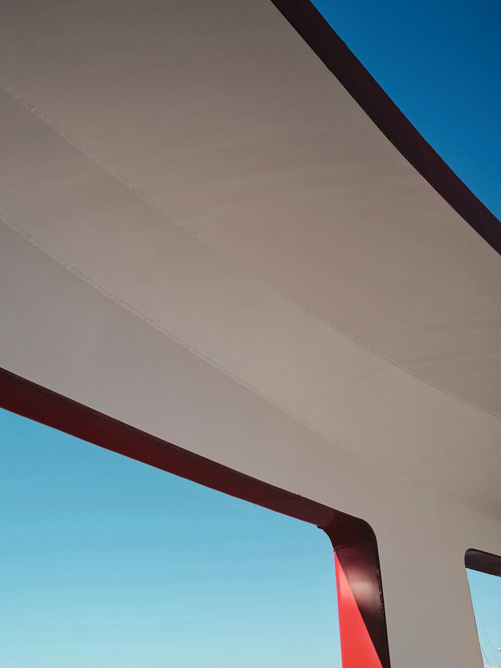 Looking out of a window at the blue sky, which contrasts with the red trim of the paintwork on the inside of the window