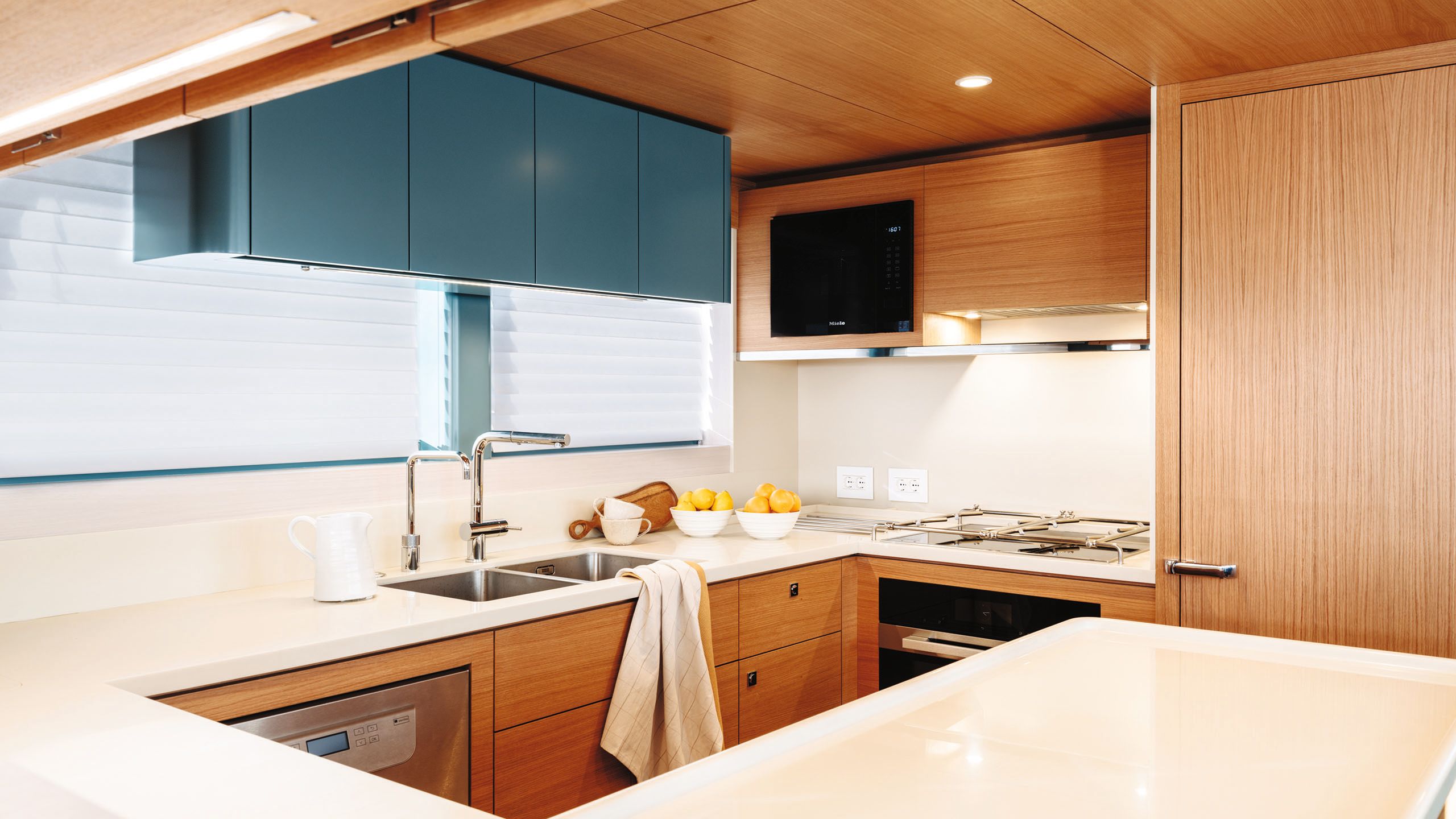 Kitchen area with light wood and teal cupboards