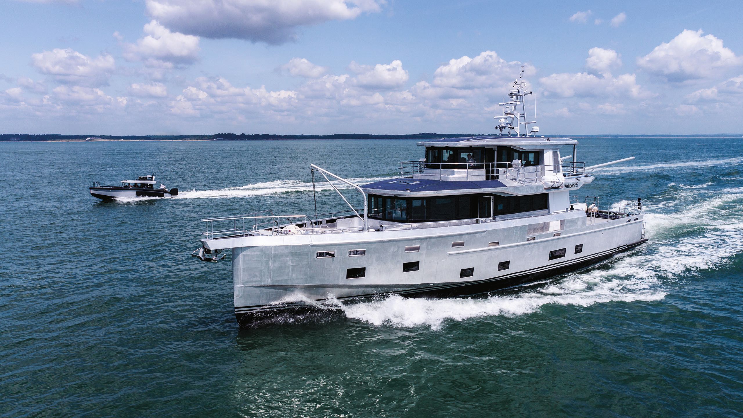 Arksen from the side on the water with a small boat to the left