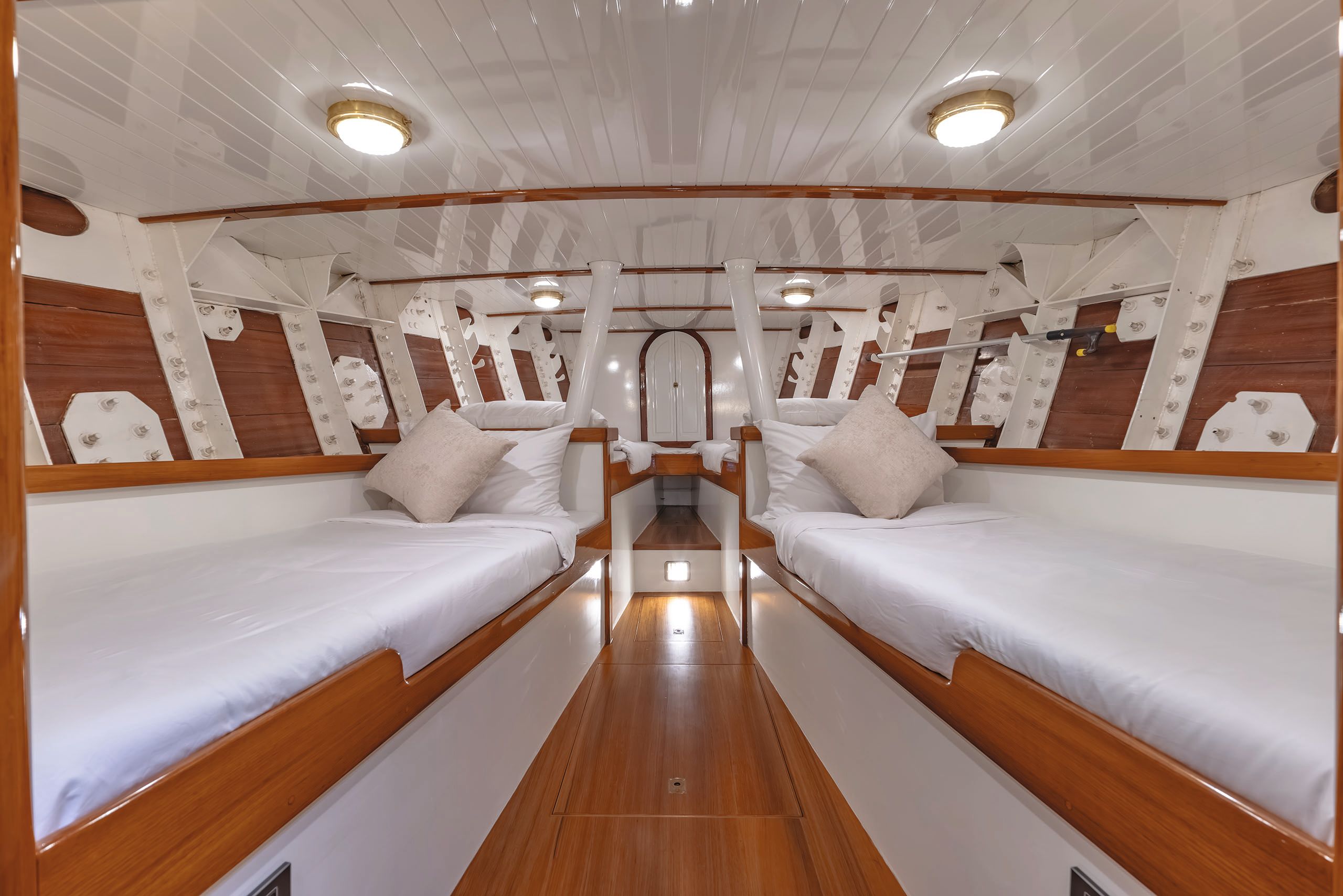Interior of sleeping quarters - the decor is white and teak with single beds