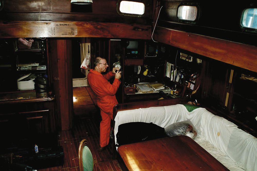 Man in a red jumpsuit taking a photo inside the vessel