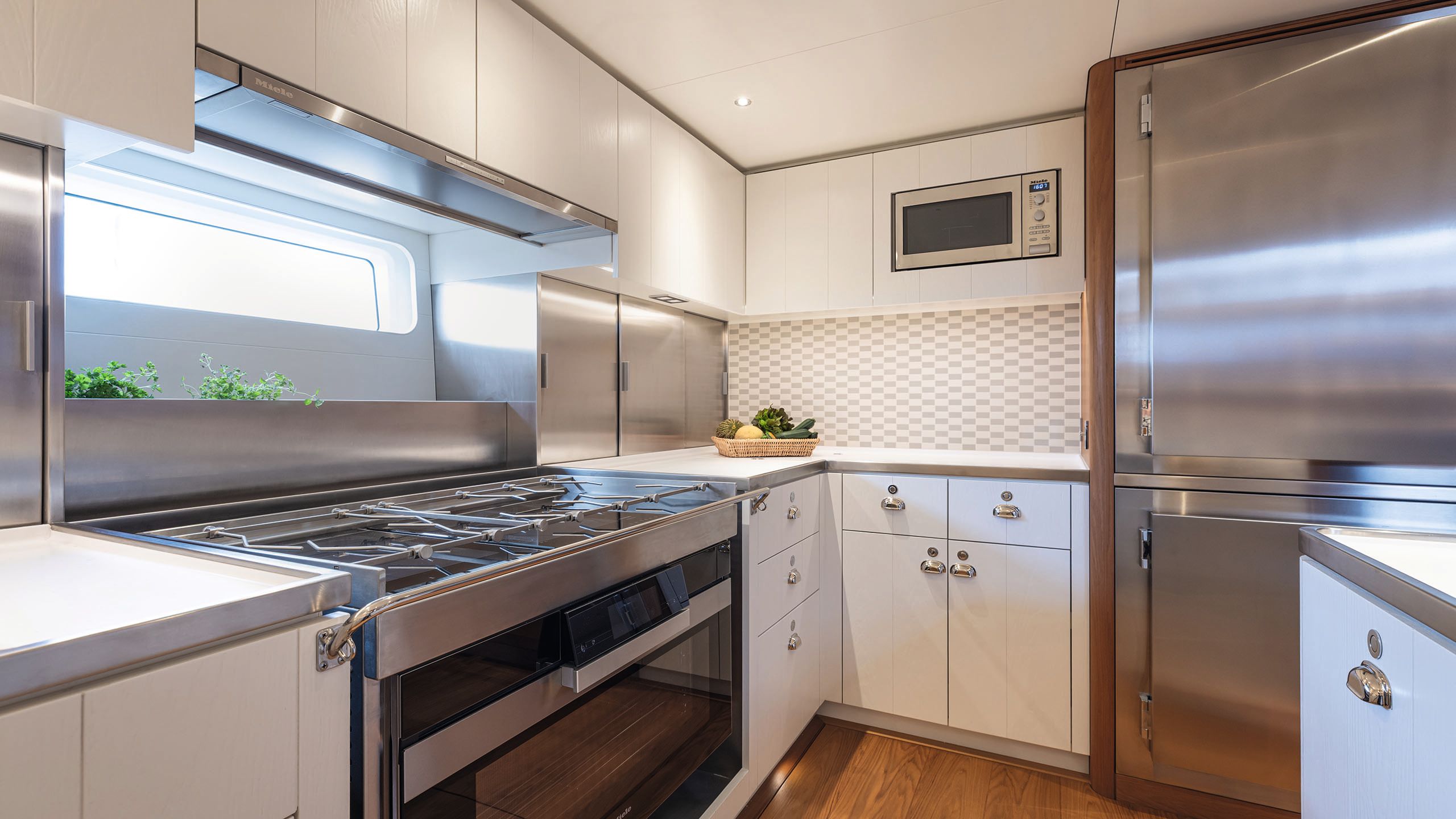 View of the kitchen area which is done out in stainless steel and white cabinetry