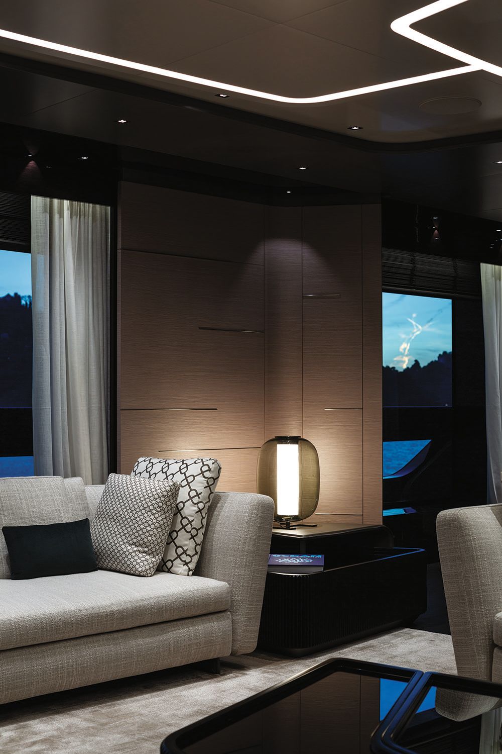 Close-up of the sofa arm and a smoked glass table lamp