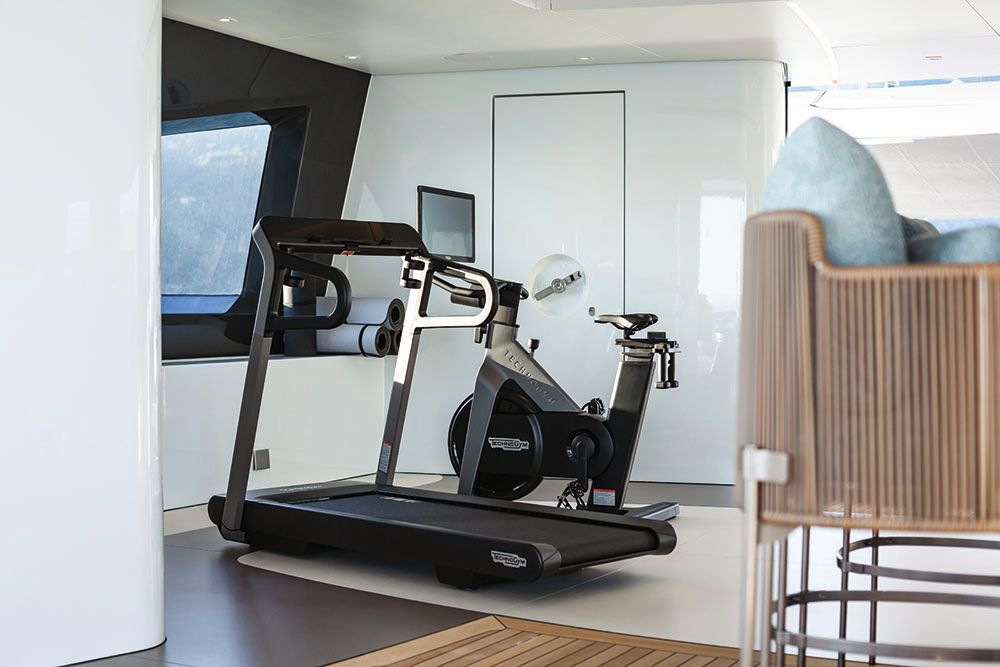 A black treadmill facing a window