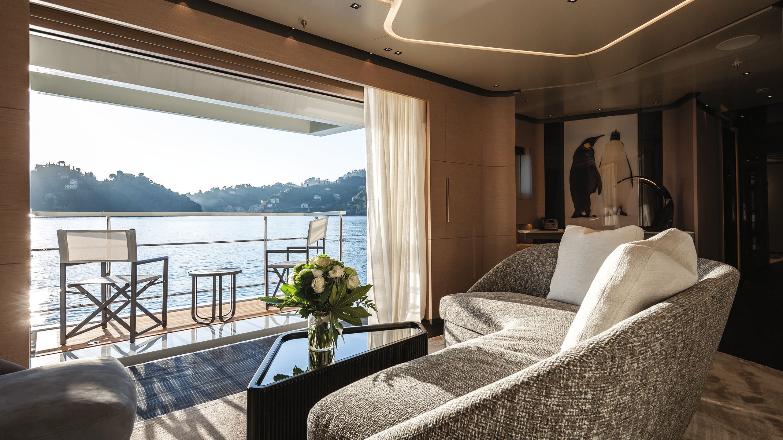 Looking out of the cabin on to a balcony which has two chairs and a table on it