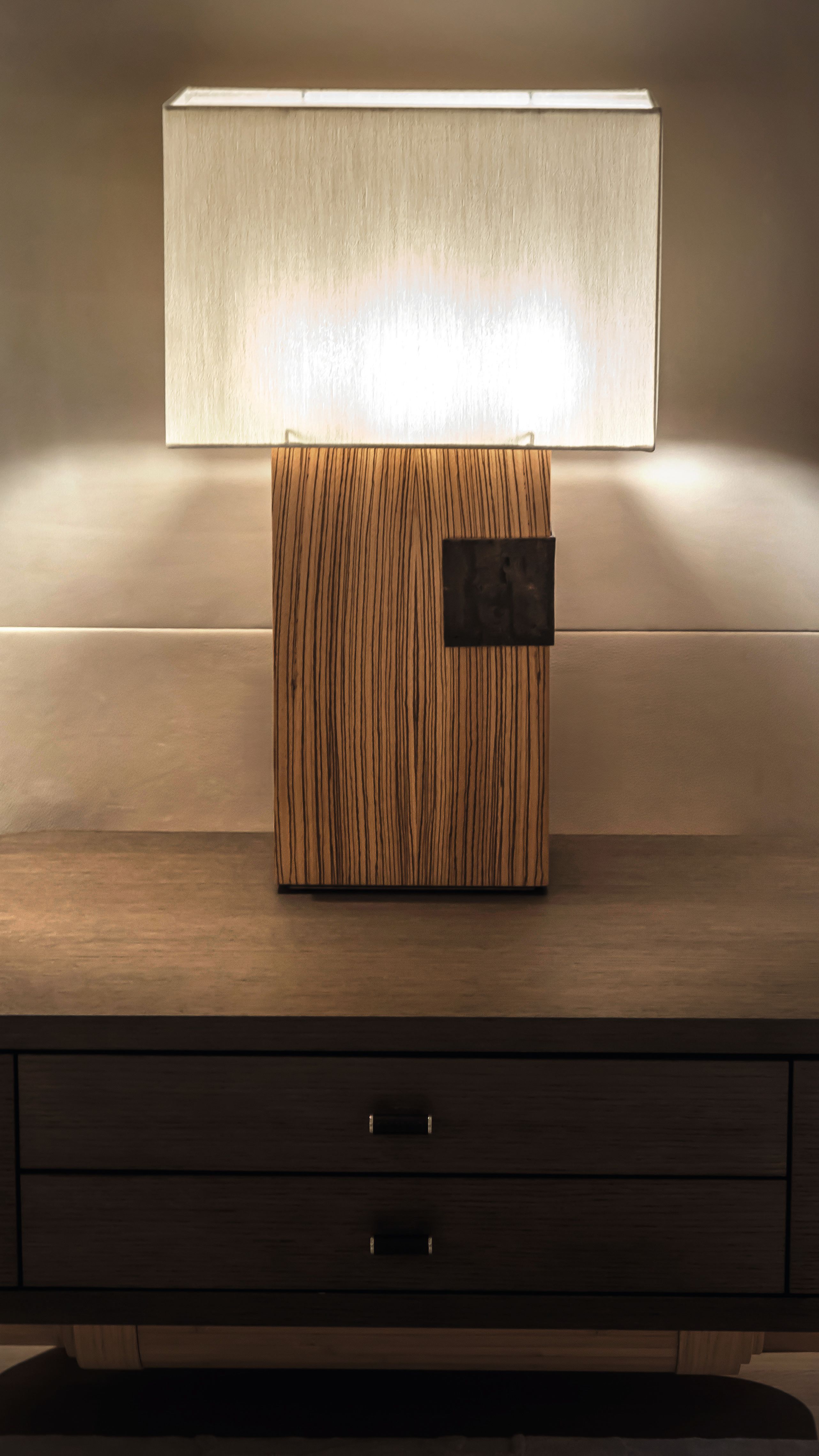 A lamp with square cream shade on a wooden table
