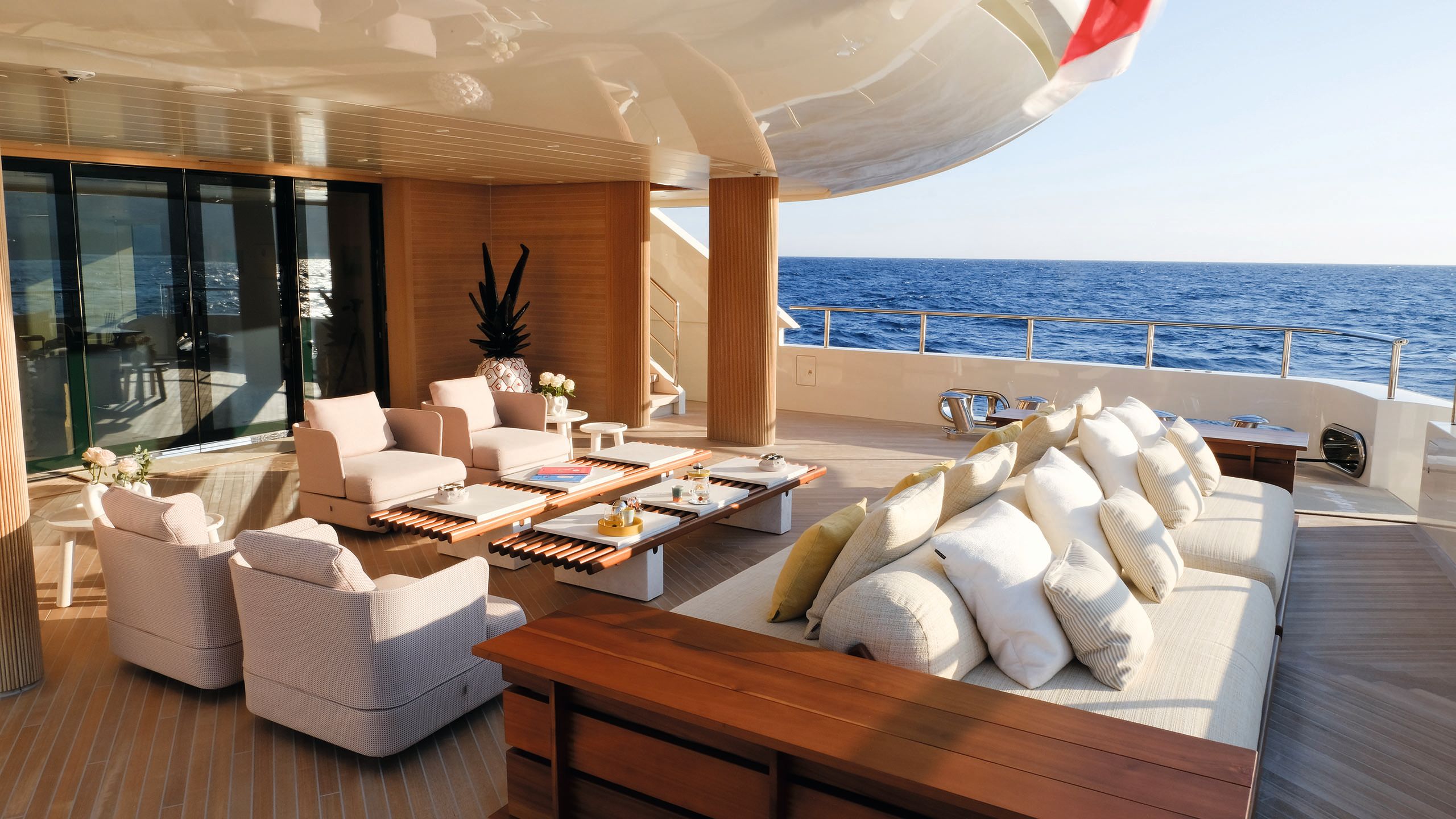 Wider view of the covered outdoor deck area which has cream armchairs