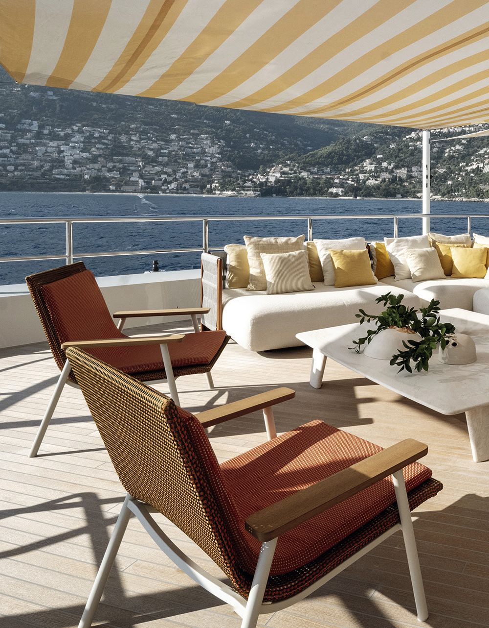 A close-up of a different style of deck chair - these are a walnut shade of wood with burnt orange seat pads and white accents