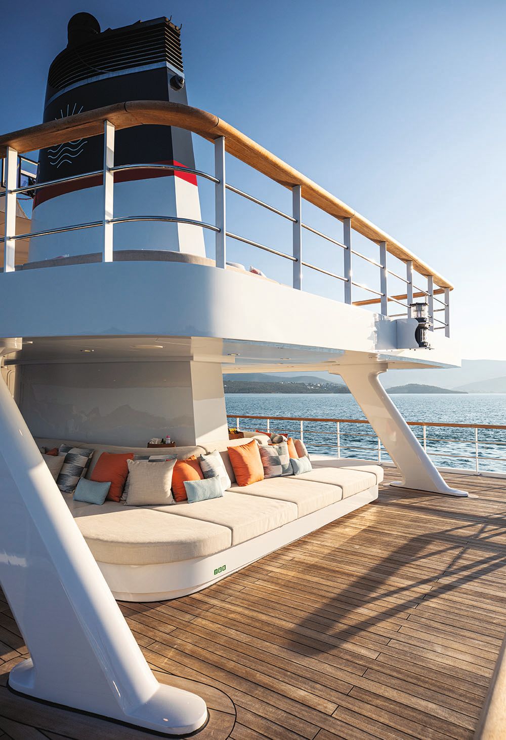 Beige sun pads on an upper deck with orange, white and blue cushions