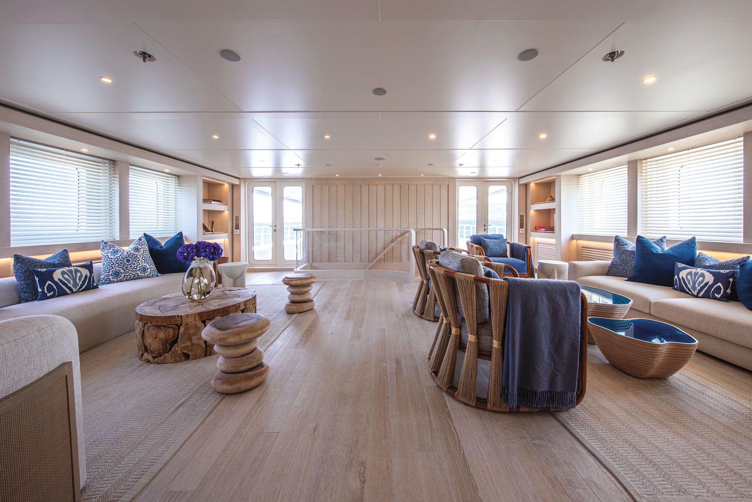 The room is now much lighter with more loose wooden furniture, neutral soft seats and blue cushions