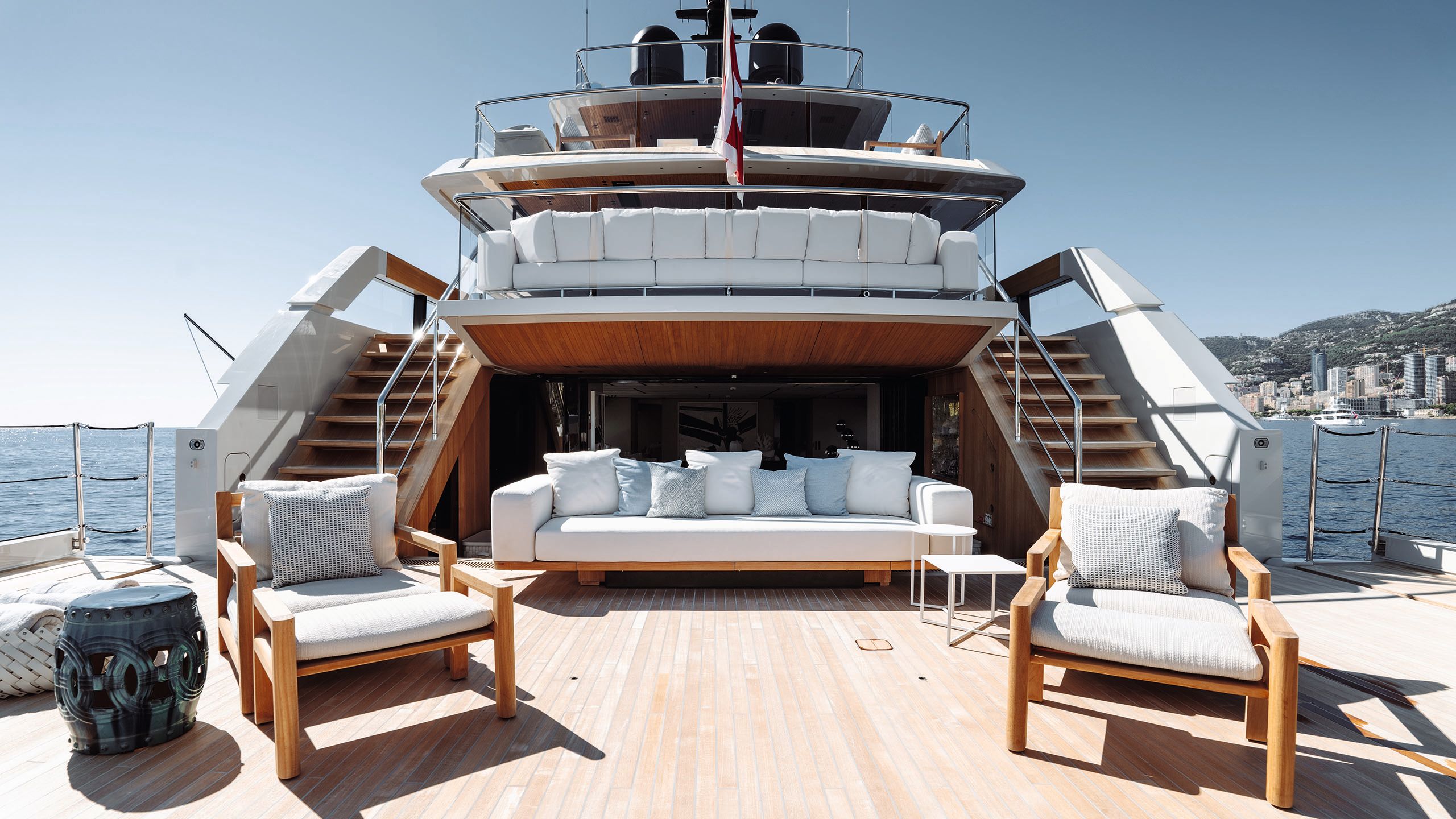 Outdoor seating area with armchairs and sofas with cream seat pads