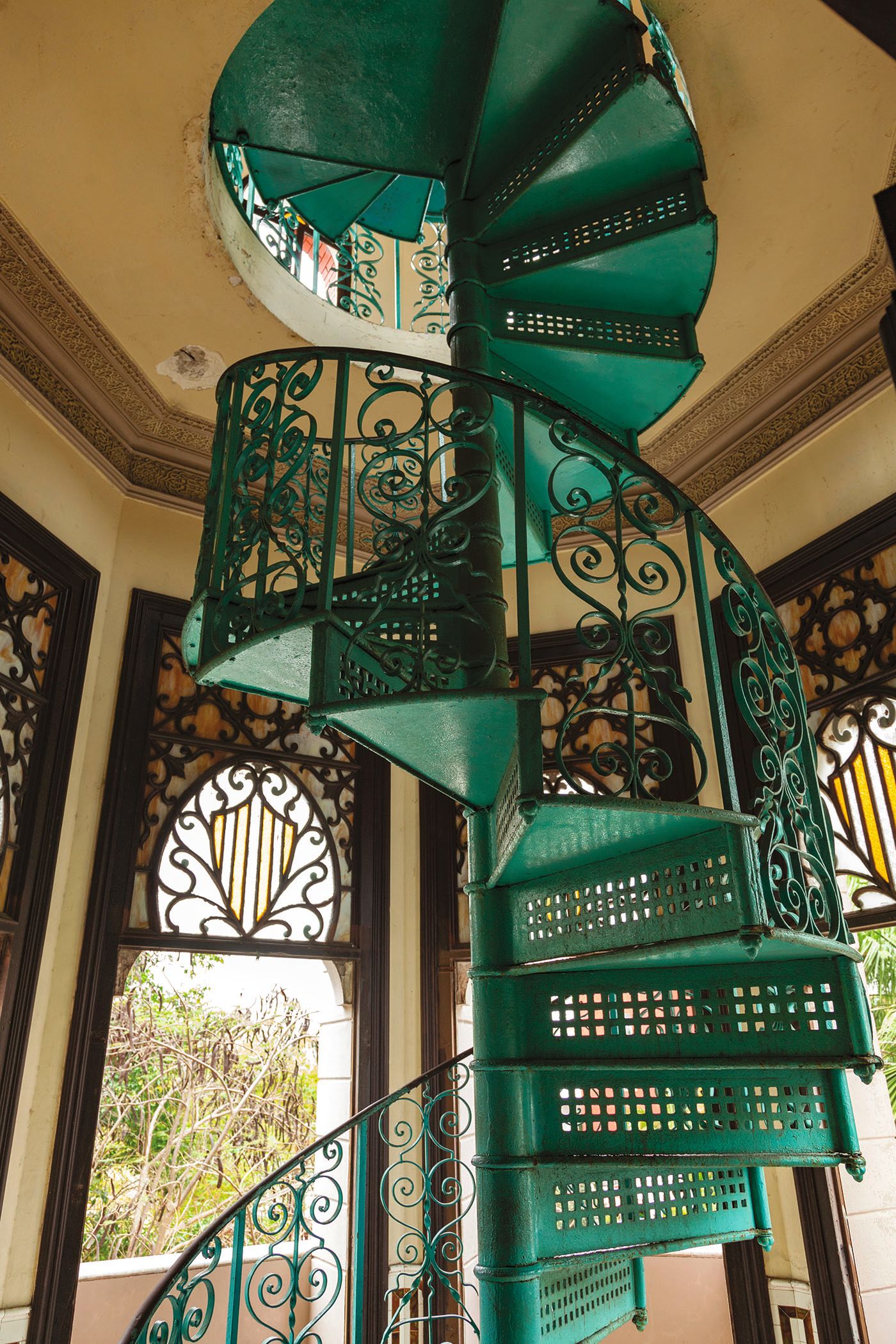 Close-up of an ornate green metal spiral staircase