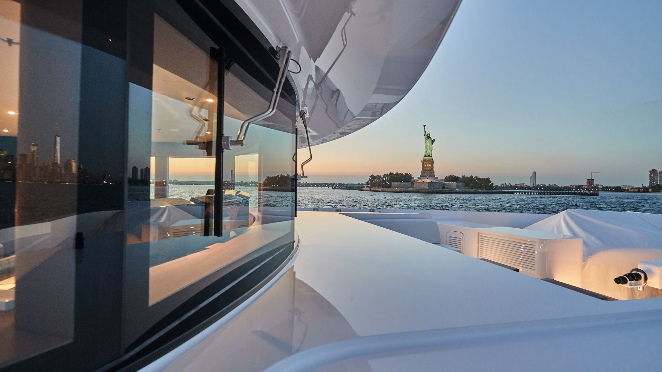Looking along the side of the boat; in the background is the Statue of Liberty and Staten Island