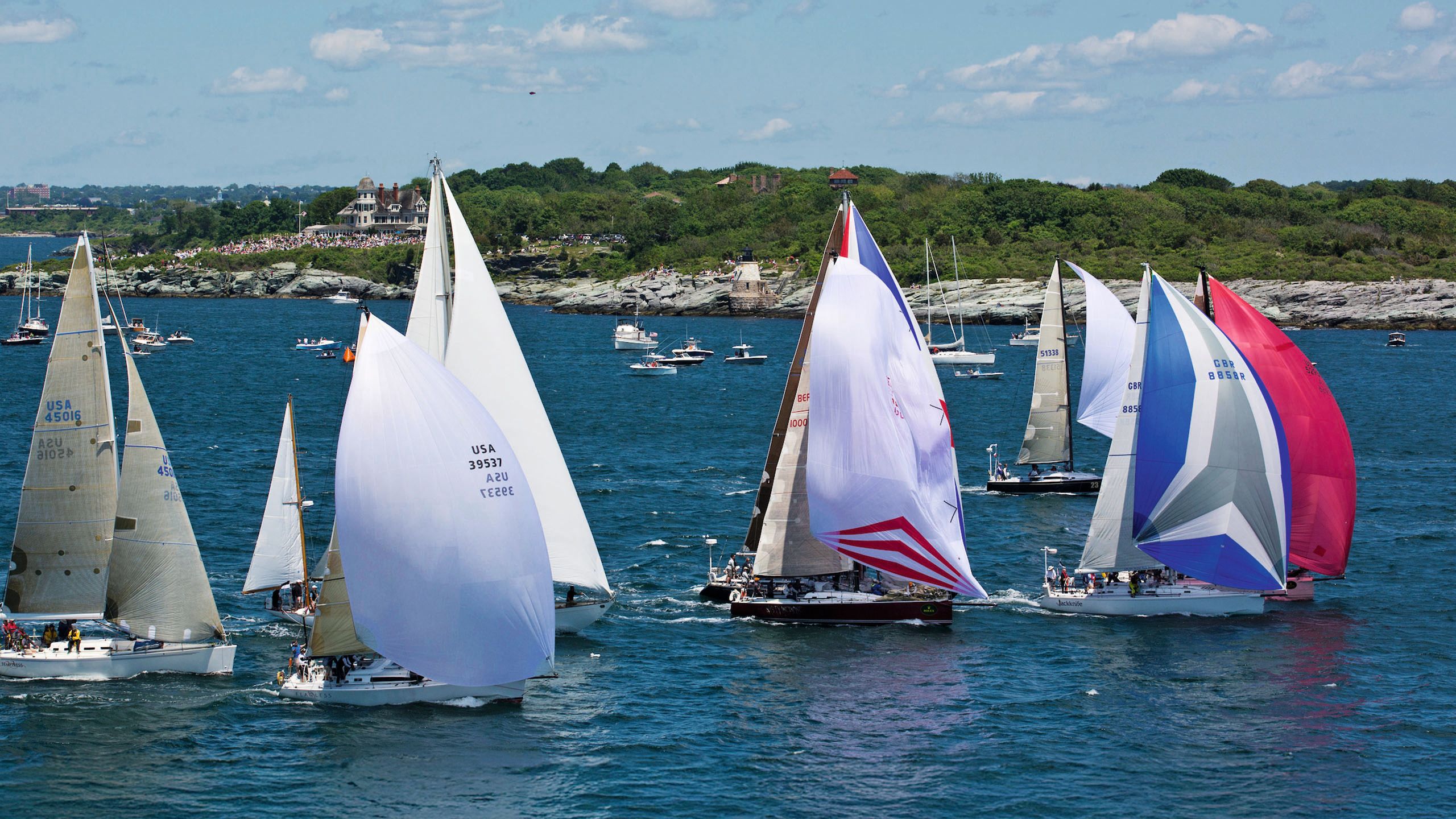 Eight sailing boat with different coloured sails on the water