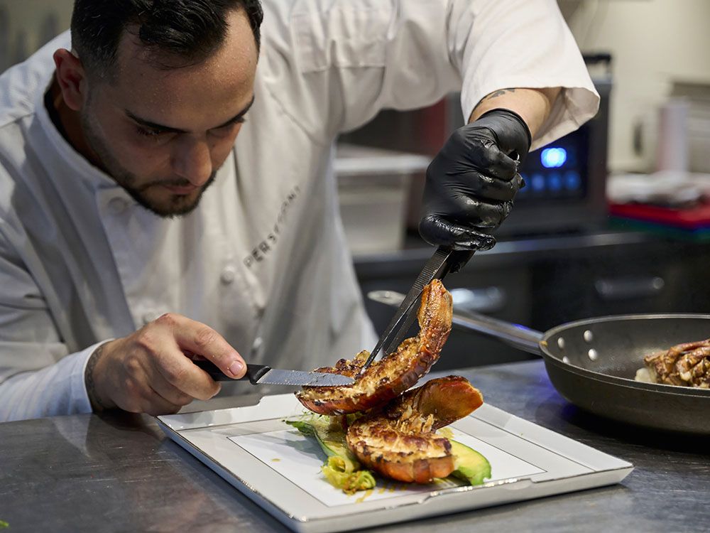 A chef serving up food on a plate