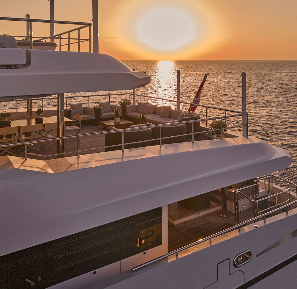 Side view from the outside, overlooking an outdoor deck at sunset