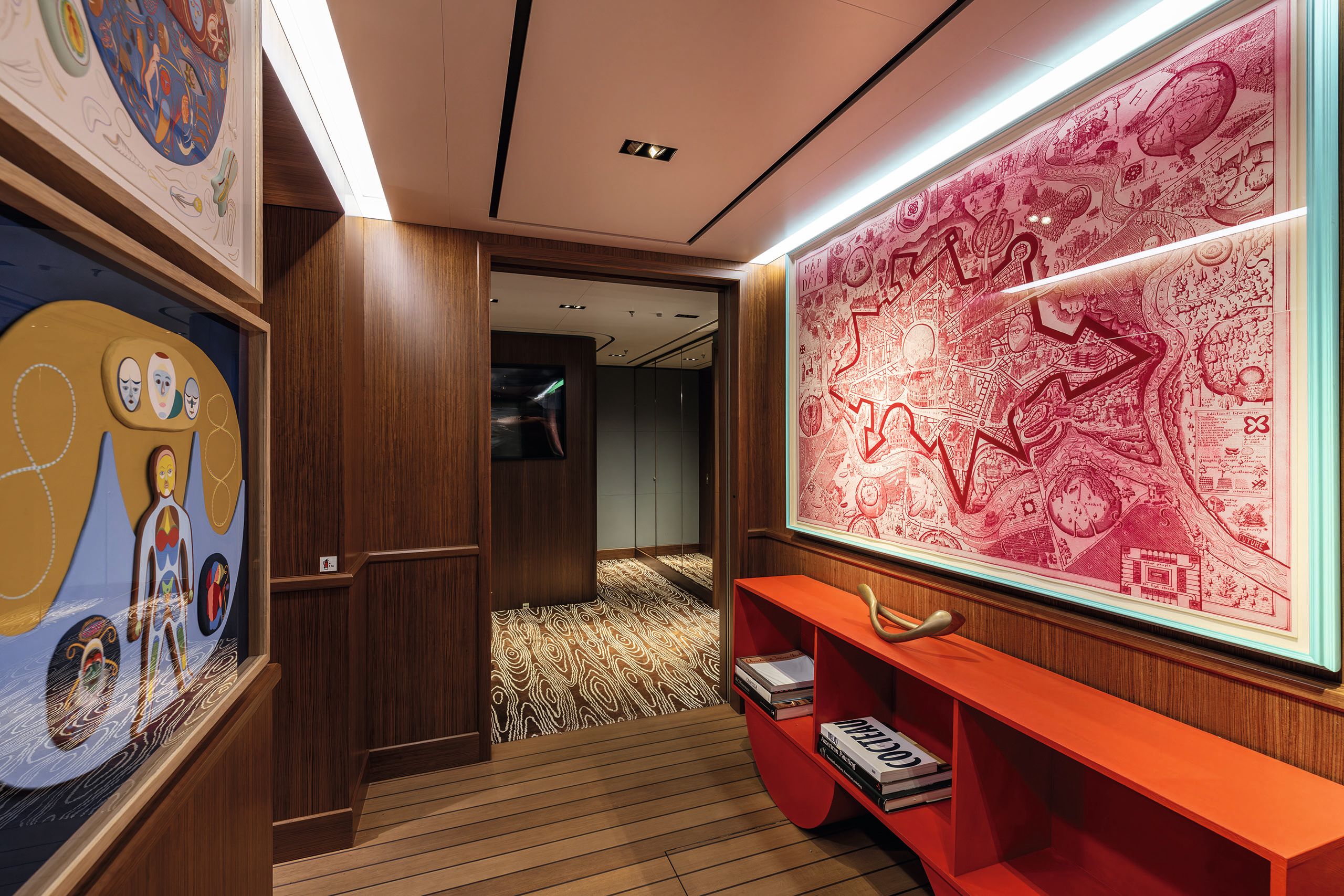 Art work on the walls in vibrant colours and a red shelf unit