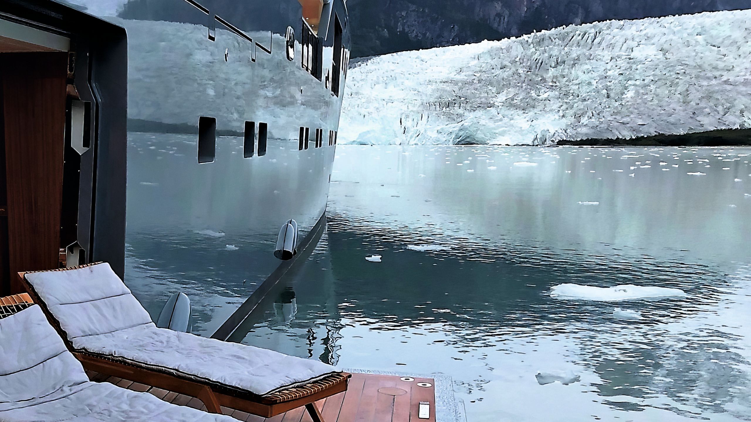 Two sun loungers on a platform stretching out from the side with a glacier in the background