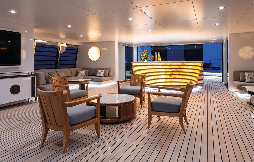 Decked area with bar at the back and chairs with low coffee table at the front