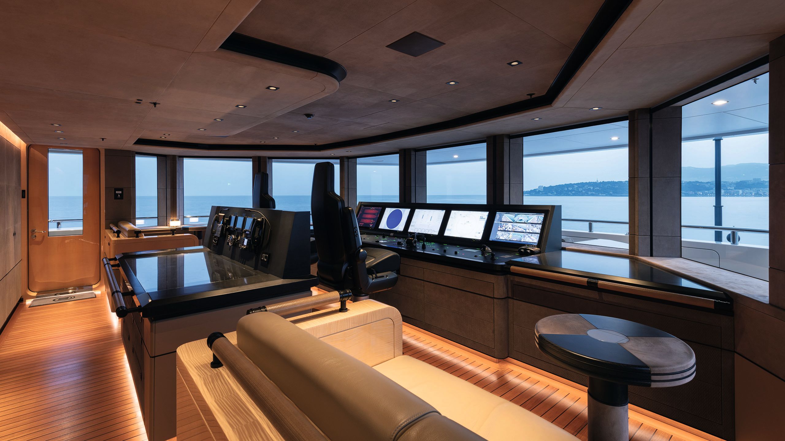 Inside the wheelhouse - there are two chairs in black leather facing a desk of controls and screens