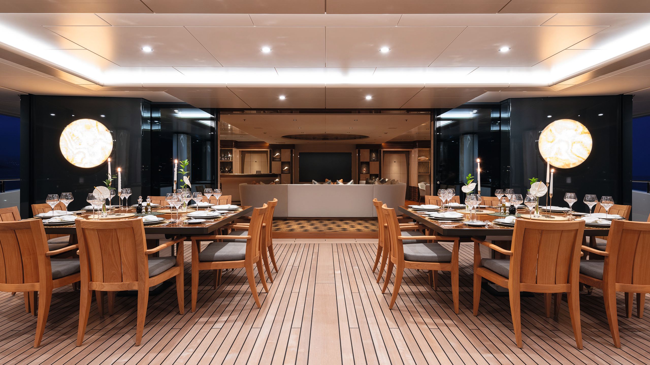 Wide shop of two dining tables opposite each other on a decked area