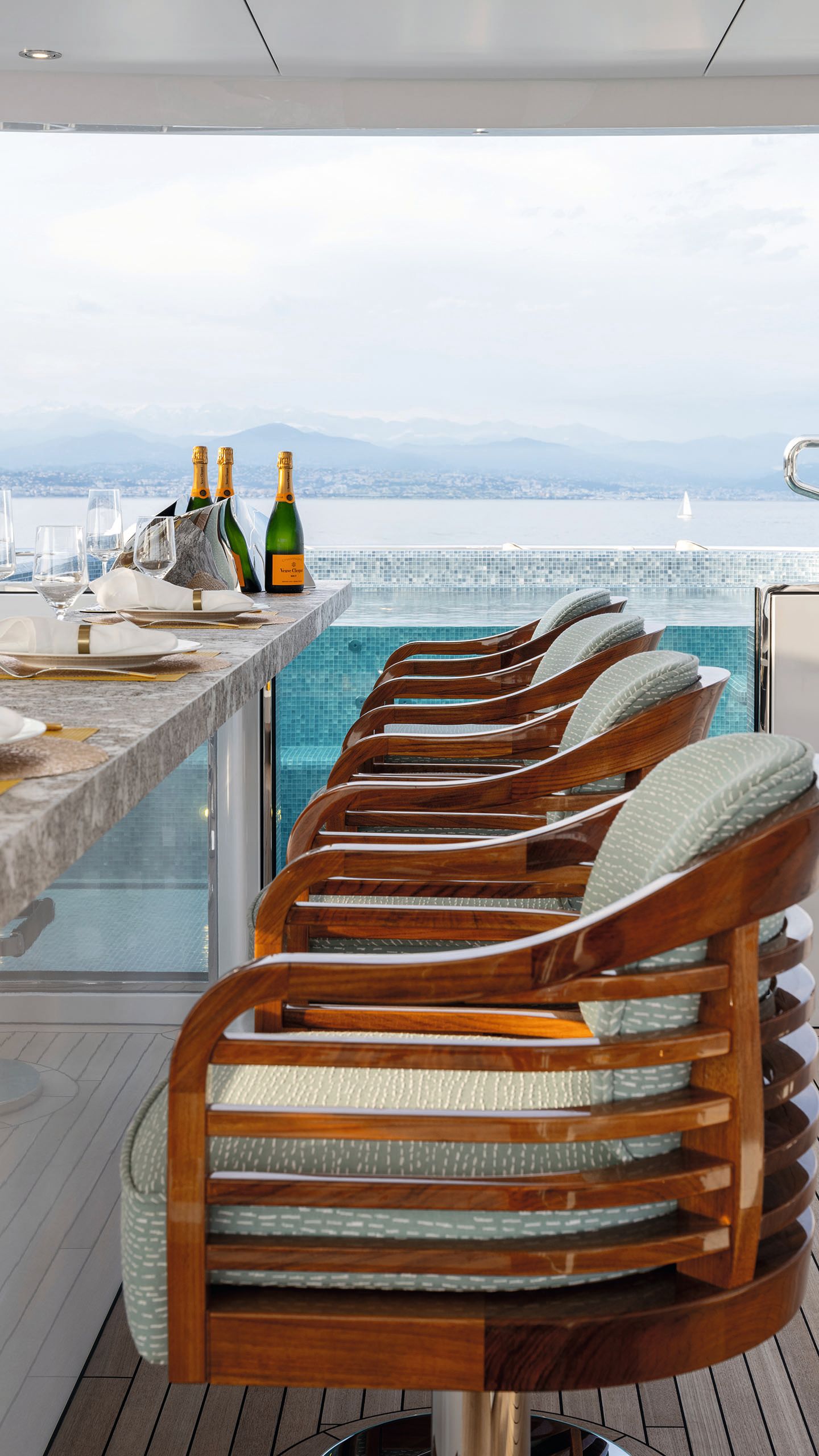 Looking down a row of chairs at the bar. Champagne bottles are at the far end