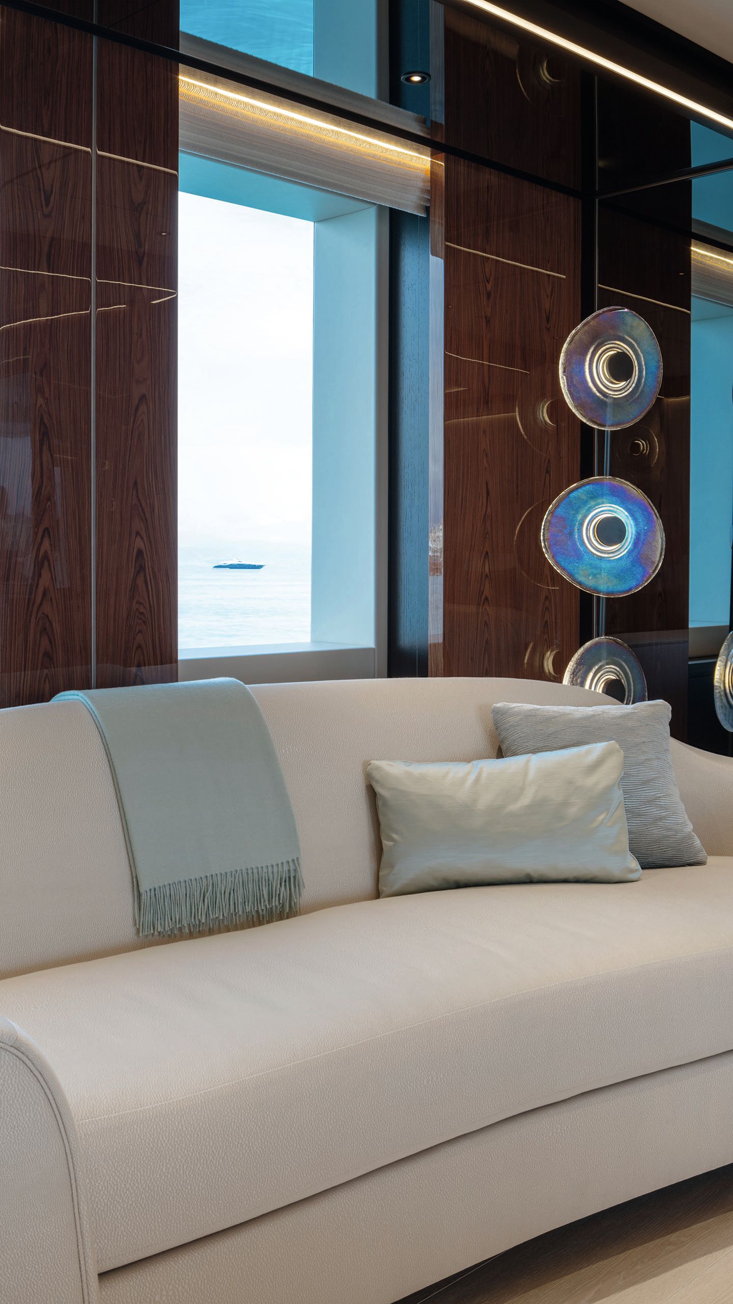  Curved white sofa with light grey cushions and throw