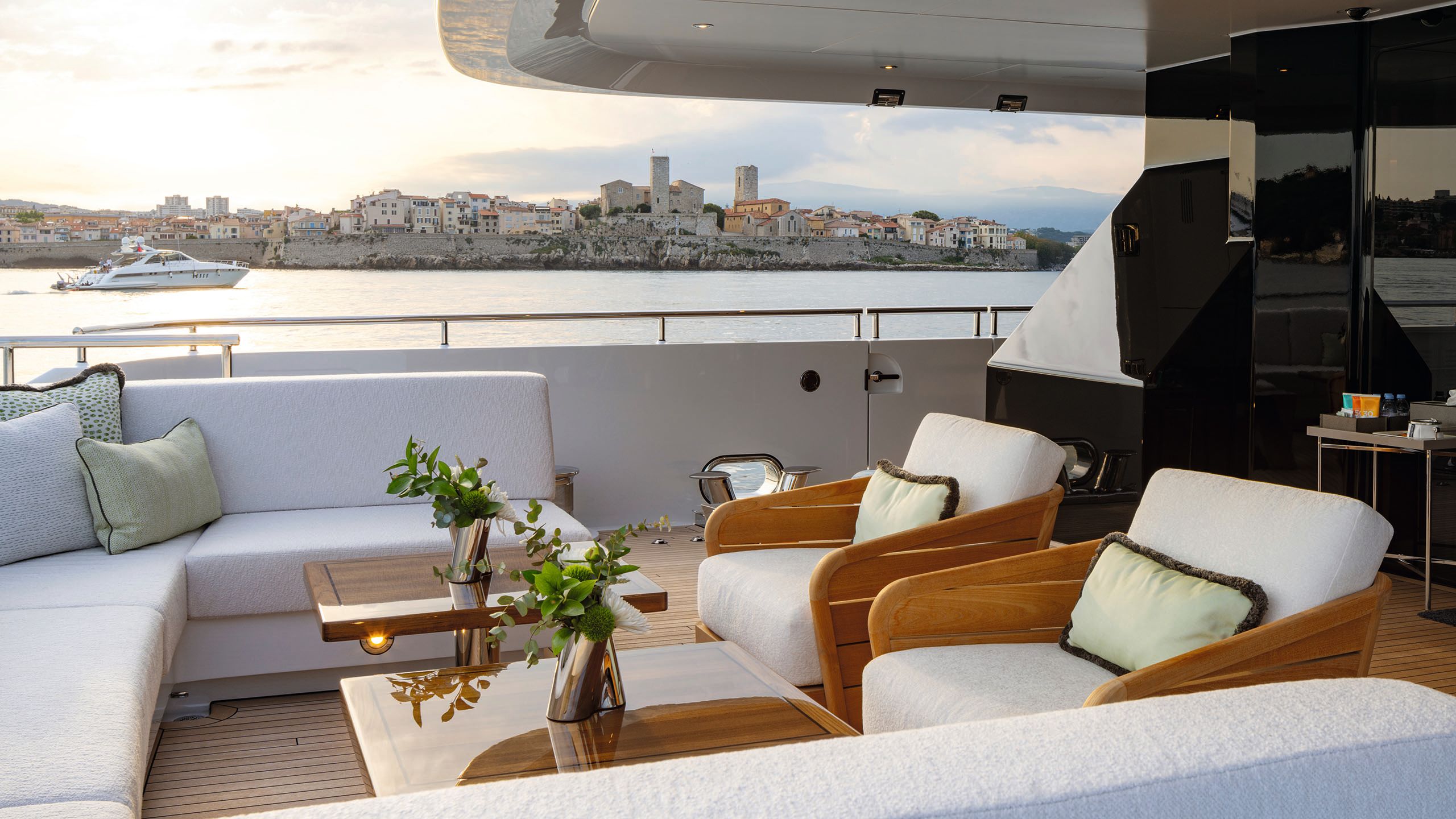 A partially covered outdoor deck with soft seating in the form of sofas and loose armchairs