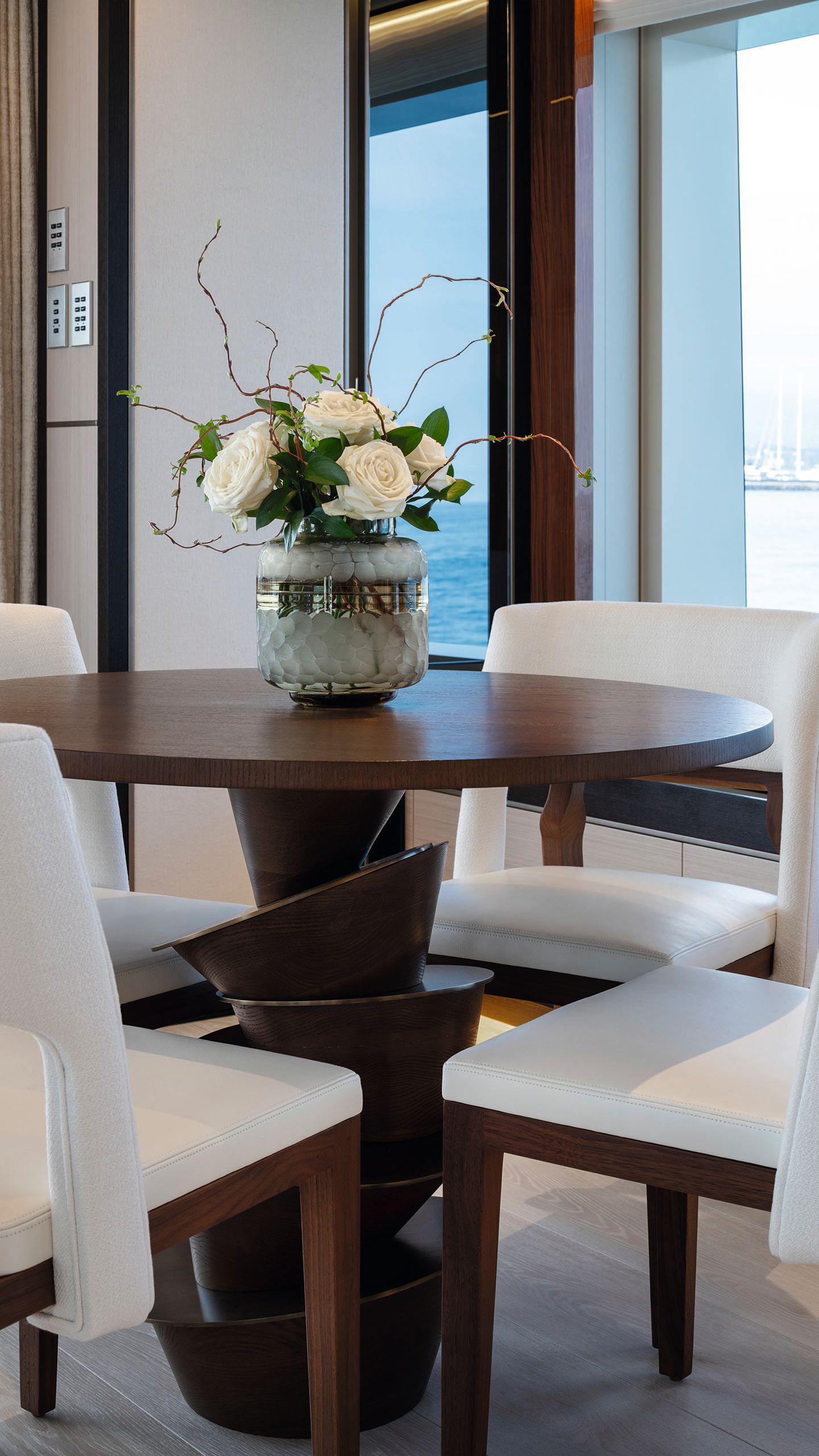 A round mahogany coloured table with four white seats