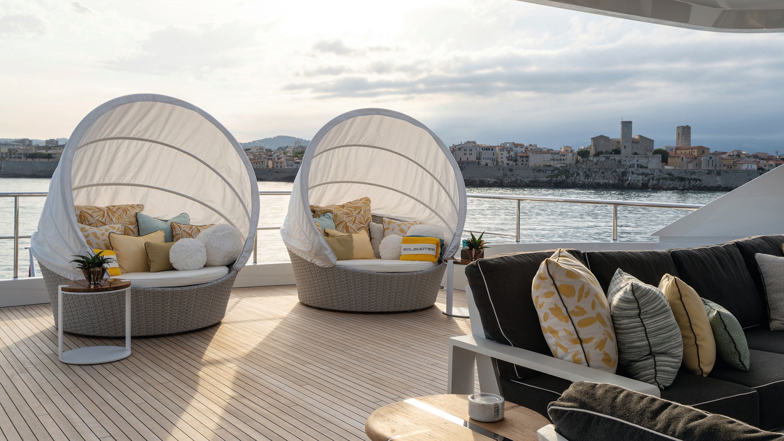 Two large canopy loveseats on an outdoor deck covered with cushions