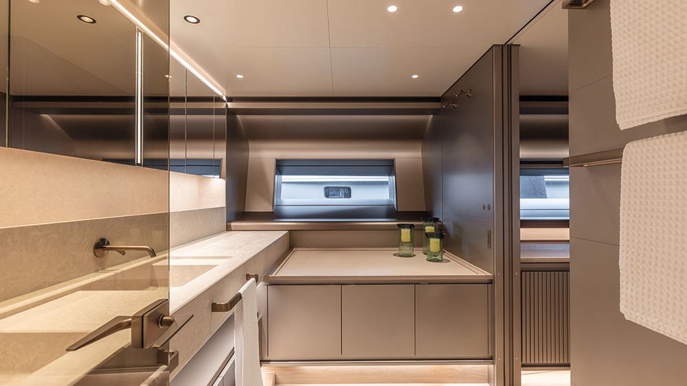 A kitchen area on the boat which is decorated in neutral beiges and taupes with bronze fixtures