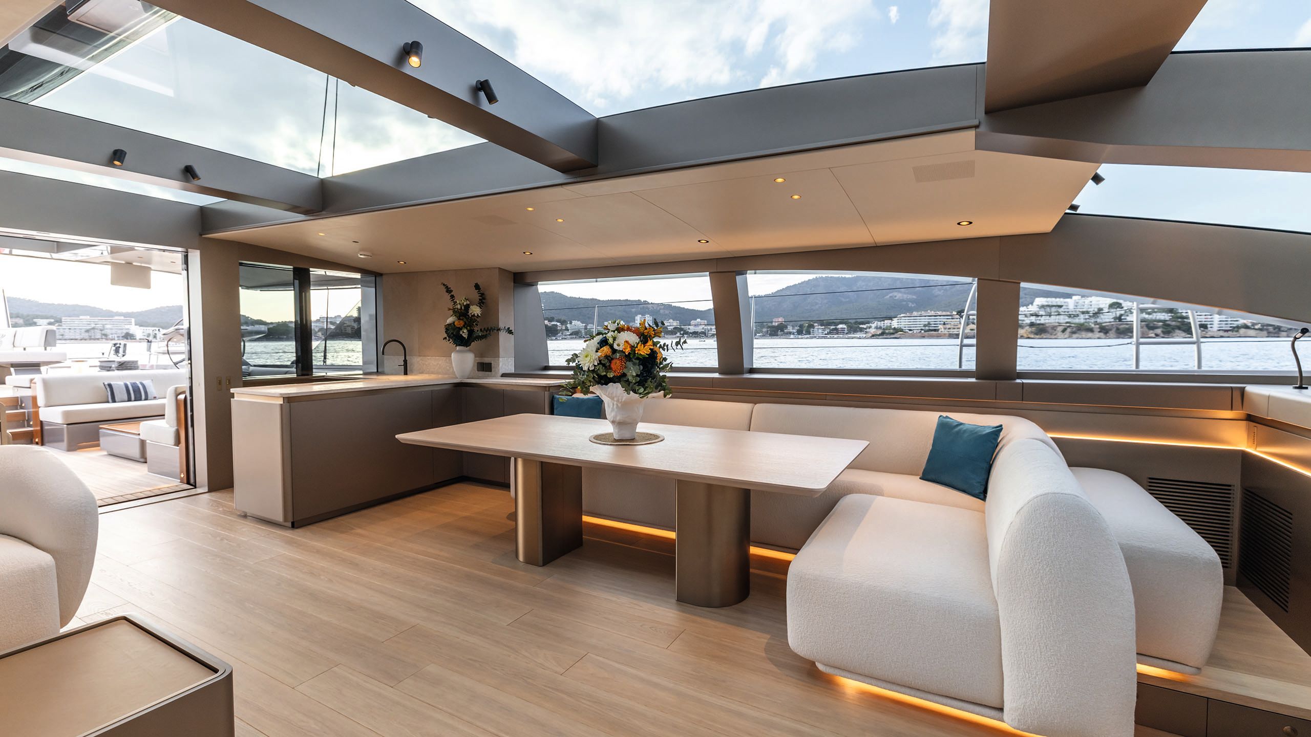 An L-shaped white sofa facing the doors the open out on to the covered lounge area