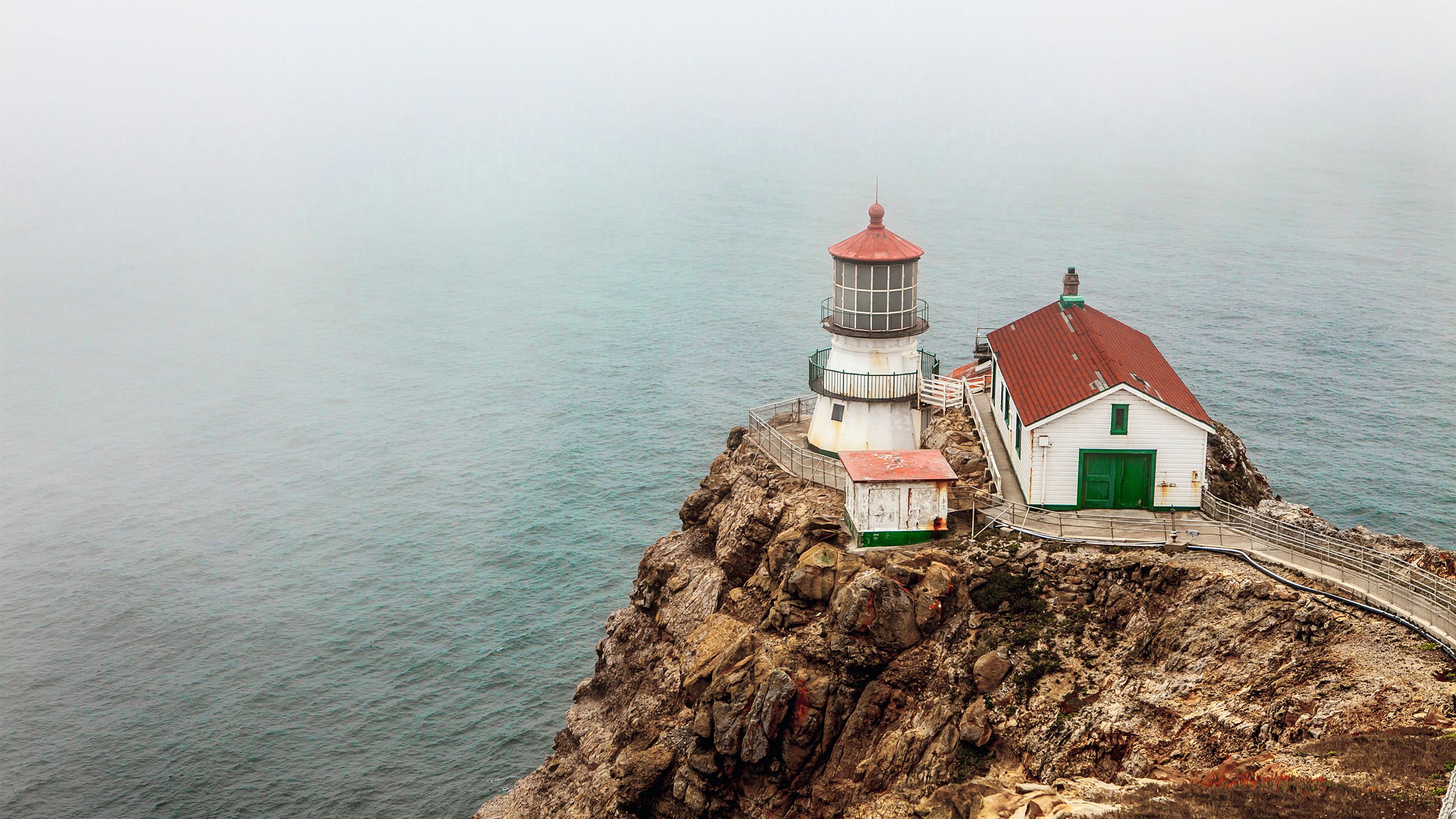 Overlooking a foggy outcrop with lighthouse in Maine